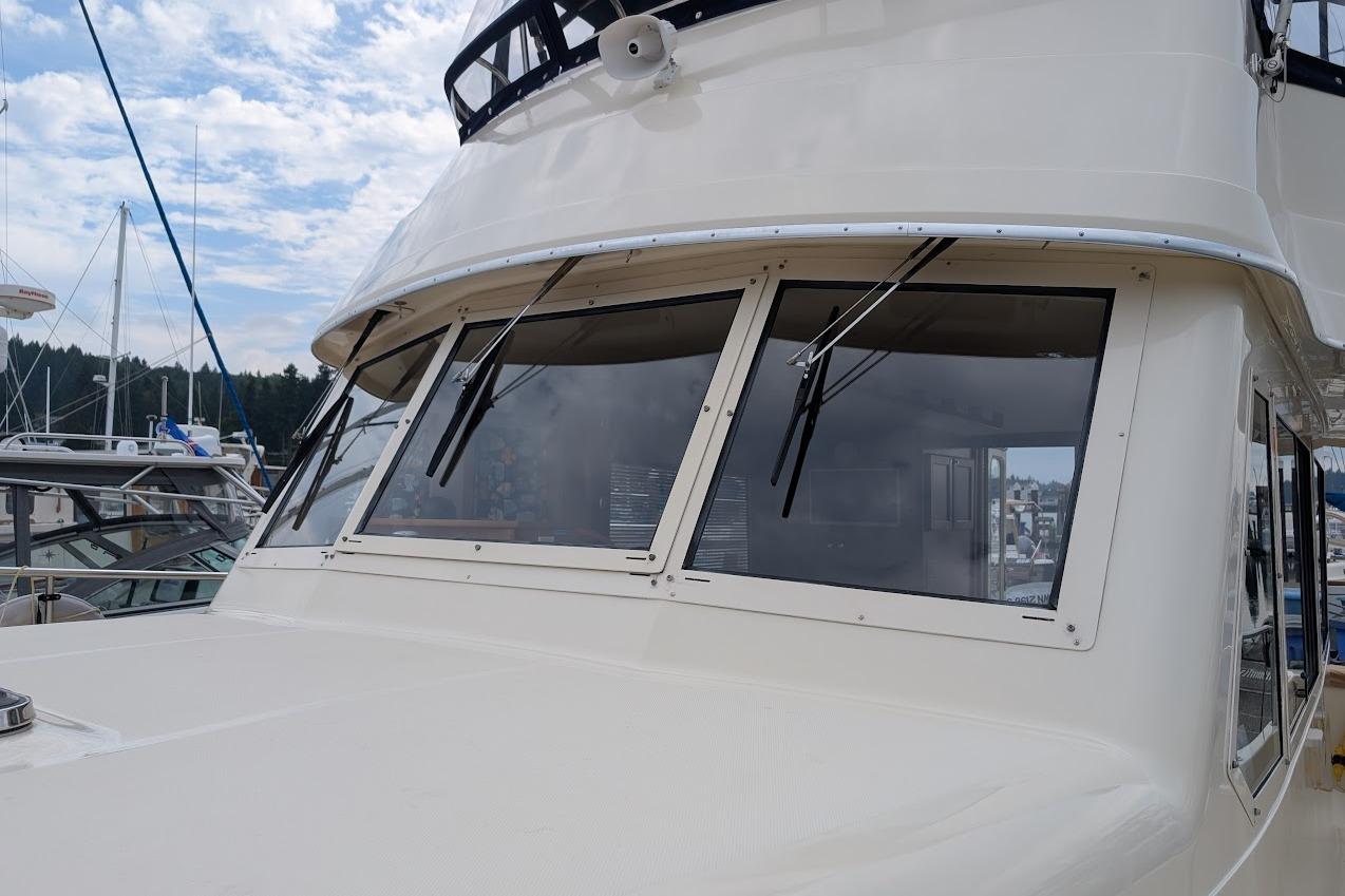 2008 Mainship 38 yacht with sleek windows and wipers, docked at a marina.