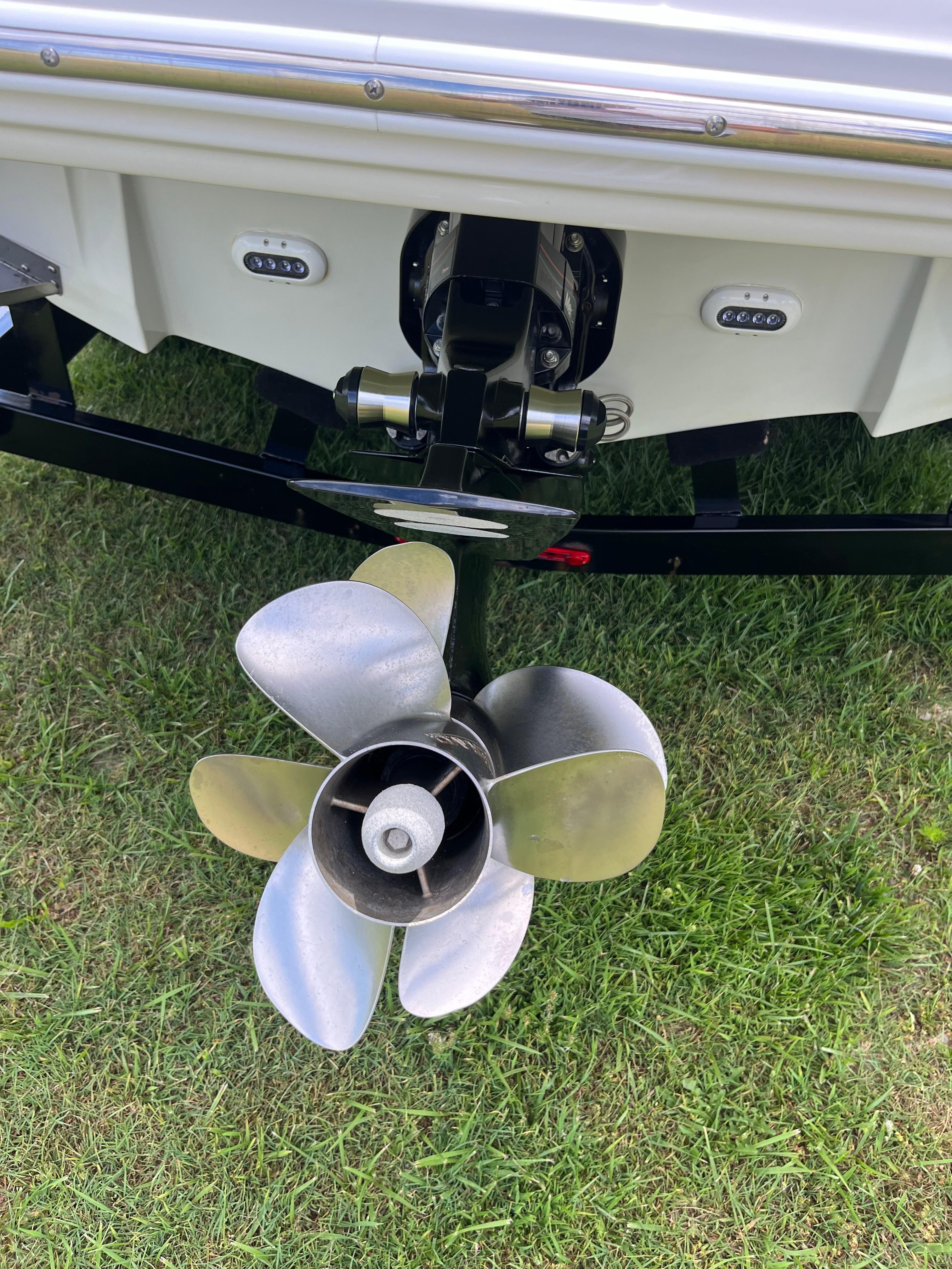 Close-up of a boat propeller on a 2019 Crownline E 285, parked on grass.