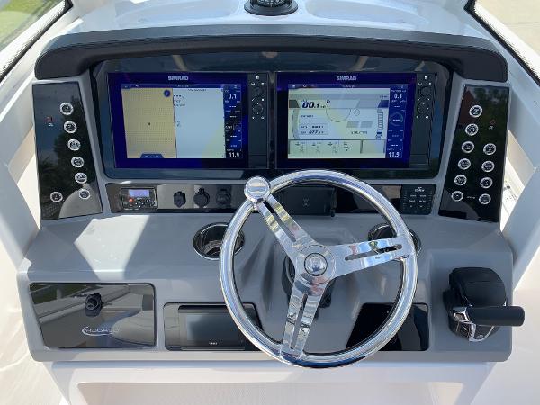 2024 Robalo 266 Cayman boat dashboard with dual Simrad displays and chrome steering wheel.