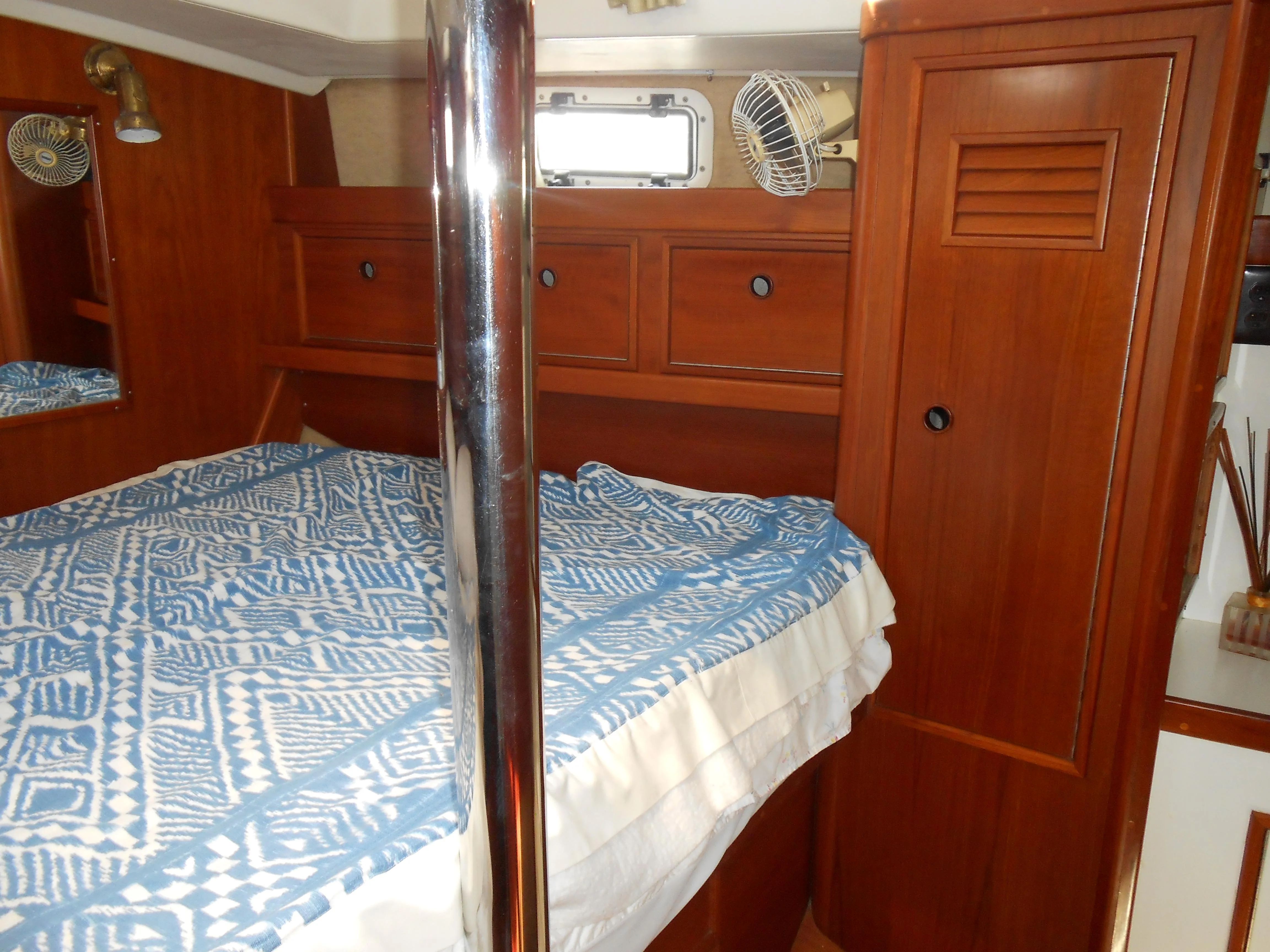 Interior of a 1985 Contest 41 Ketch with wooden furnishings and bed.