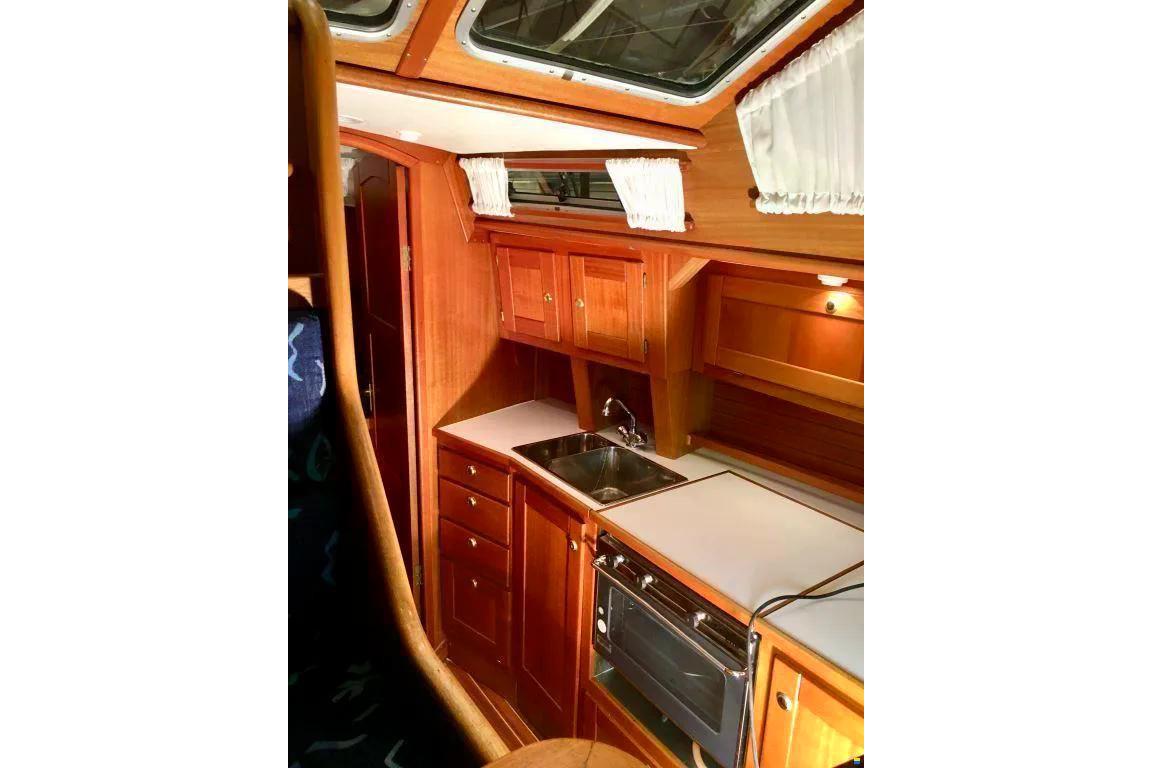 Cozy wooden interior of 1998 Nordship 35 DS sailboat kitchen area.