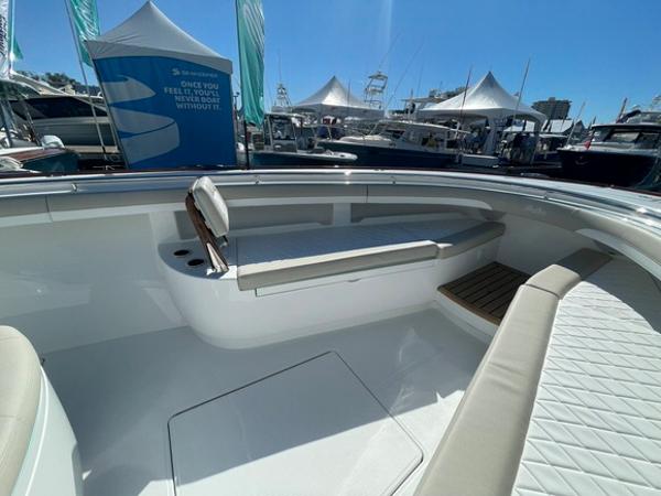 2025 Mag Bay 43 Center Console boat interior at a marina with tents and boats in the background.