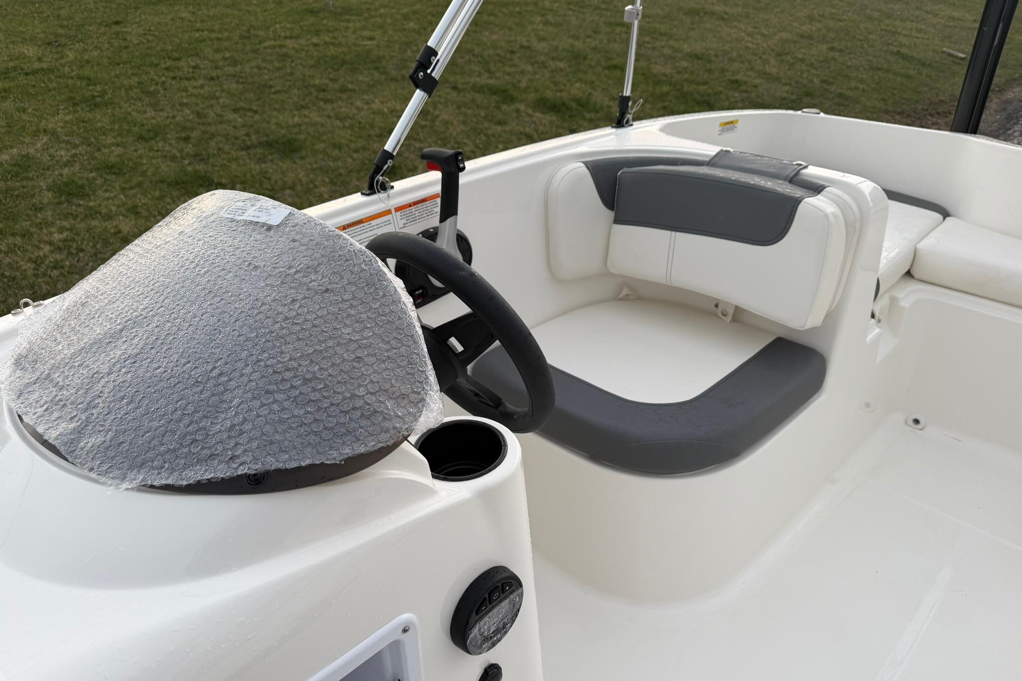 2026 Bayliner Element E16 boat interior with steering wheel and seating area.