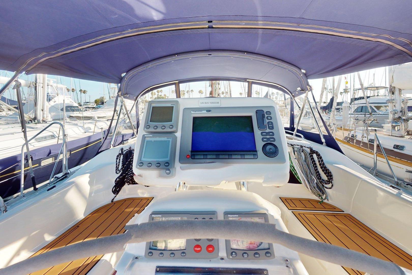 Cockpit view of 1997 Hunter Legend 40.5 sailboat with navigation equipment and teak flooring.