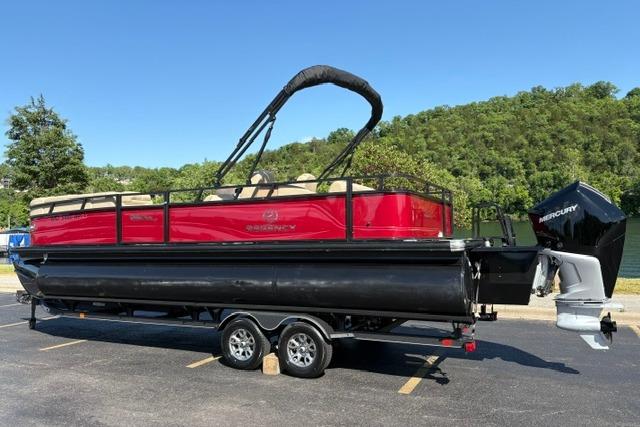 2025 Regency 250 DL3 pontoon boat with Mercury engine on trailer, parked outdoors.