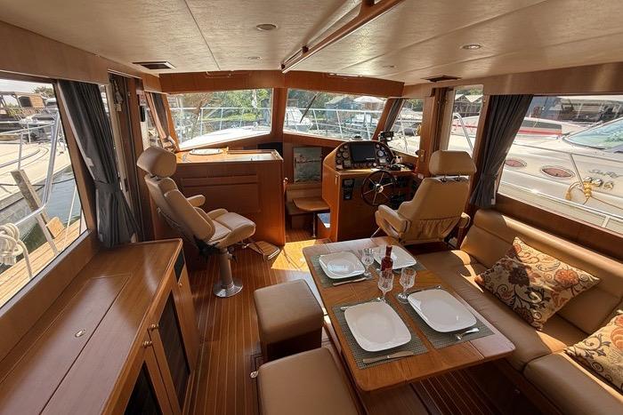 Luxurious 2007 Island Pilot 395 yacht interior with dining area and helm station.