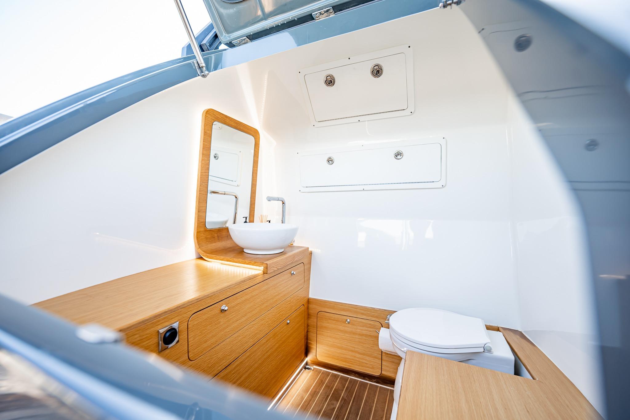 Modern bathroom interior on 2023 Skipper-BSK 38NC boat, featuring wooden cabinetry and sleek fixtures.