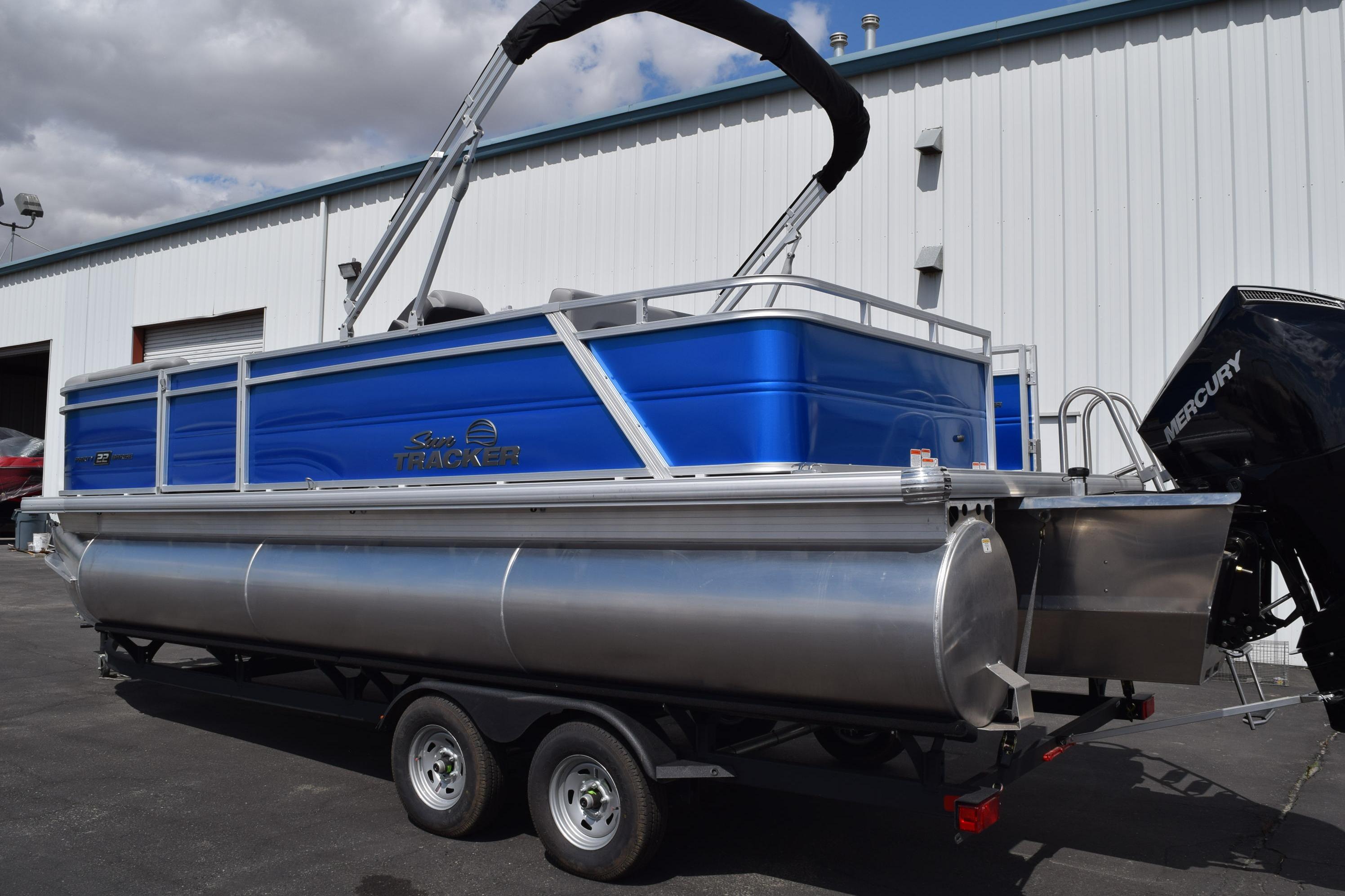 2026 Sun Tracker Party Barge 22 RF XP3 pontoon boat with Mercury engine, parked outdoors.