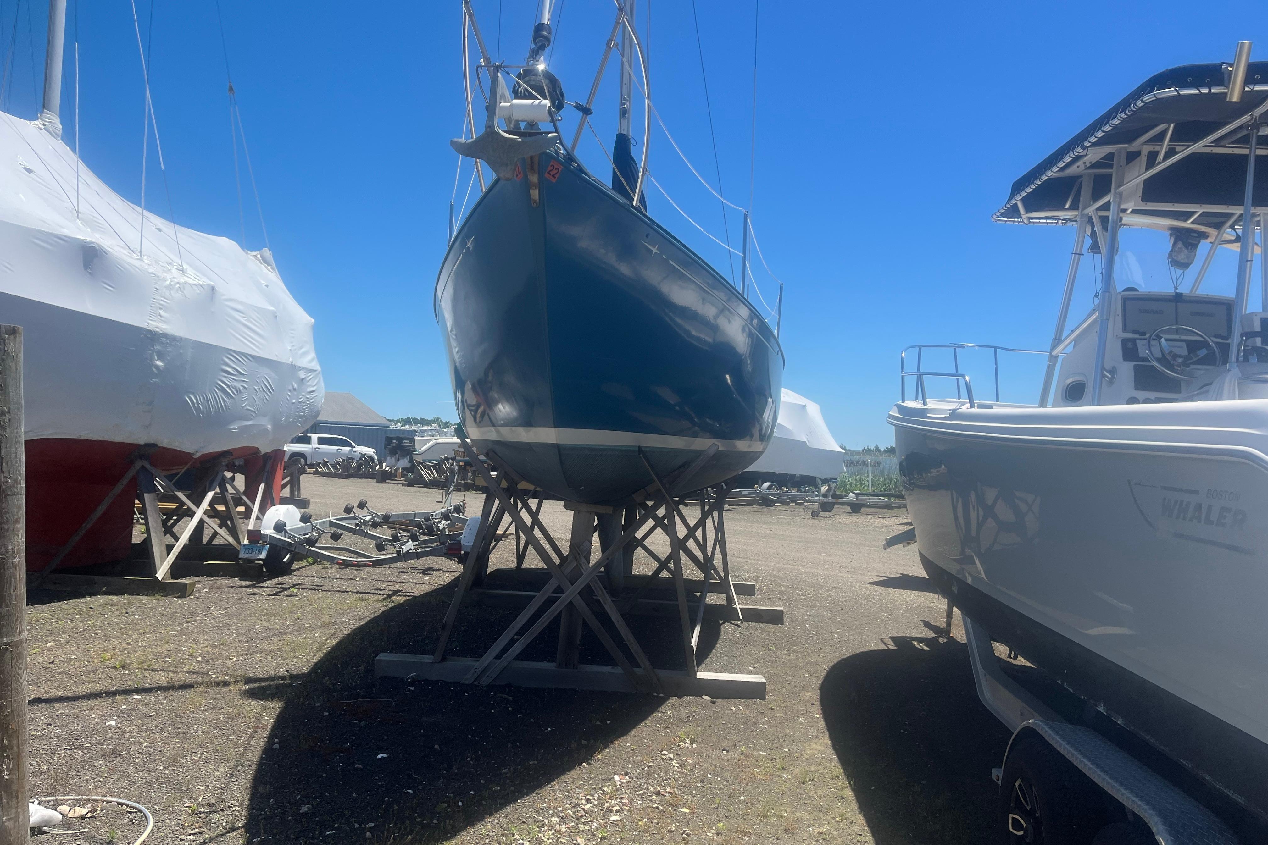 1972 C&C 30 sailboat on stands in a sunny boatyard.