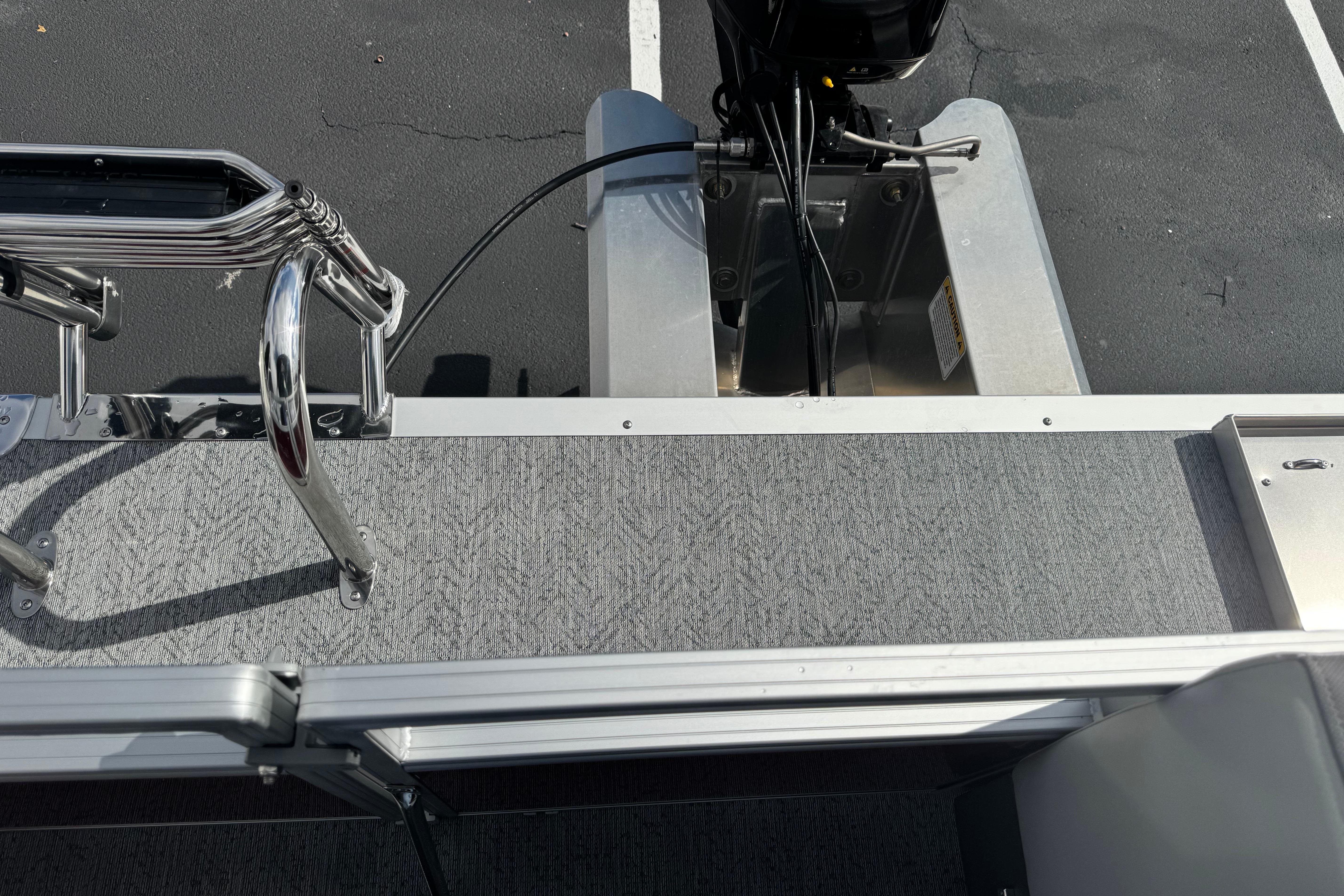 2026 Sun Tracker Bass Buggy 16 XL Select boat deck with motor and railing.