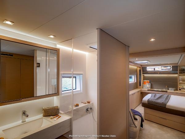 Luxurious interior of 2025 Lagoon 55 yacht featuring modern bedroom and bathroom design.