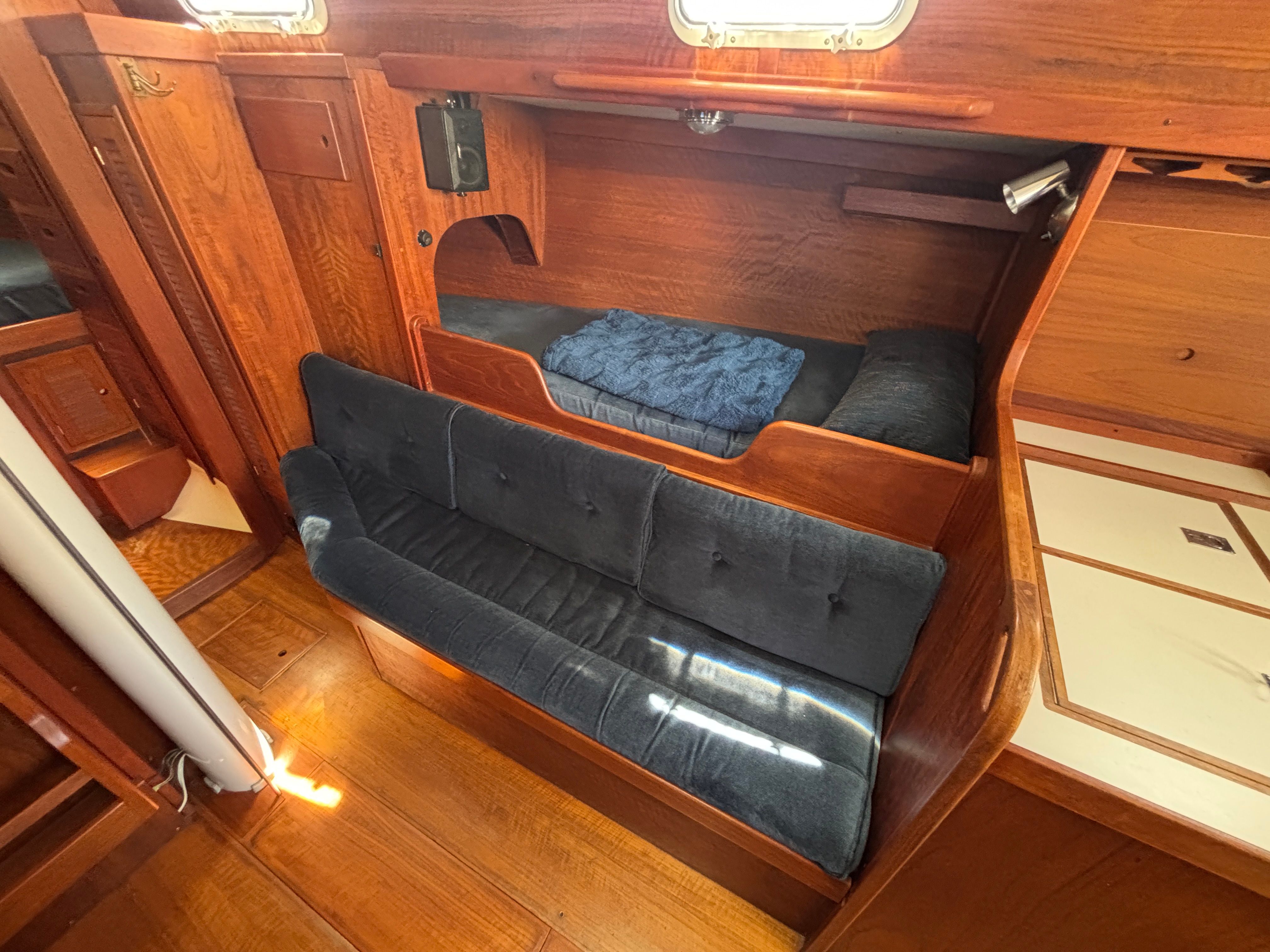 Interior of a 1979 Tartan 37 with wood finish and blue upholstery.