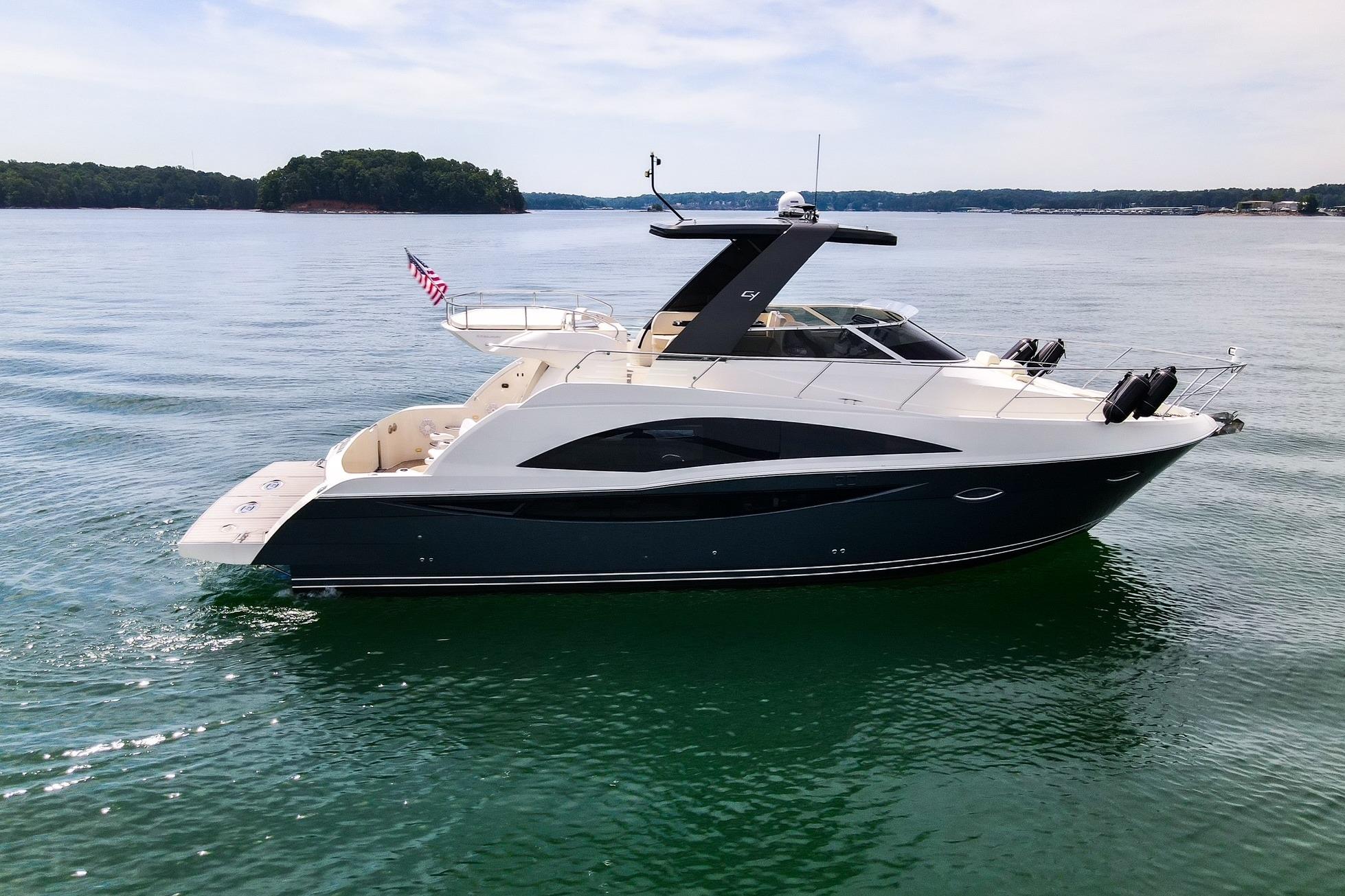 2011 Carver 44 Sojourn yacht cruising on a serene lake with lush green islands.