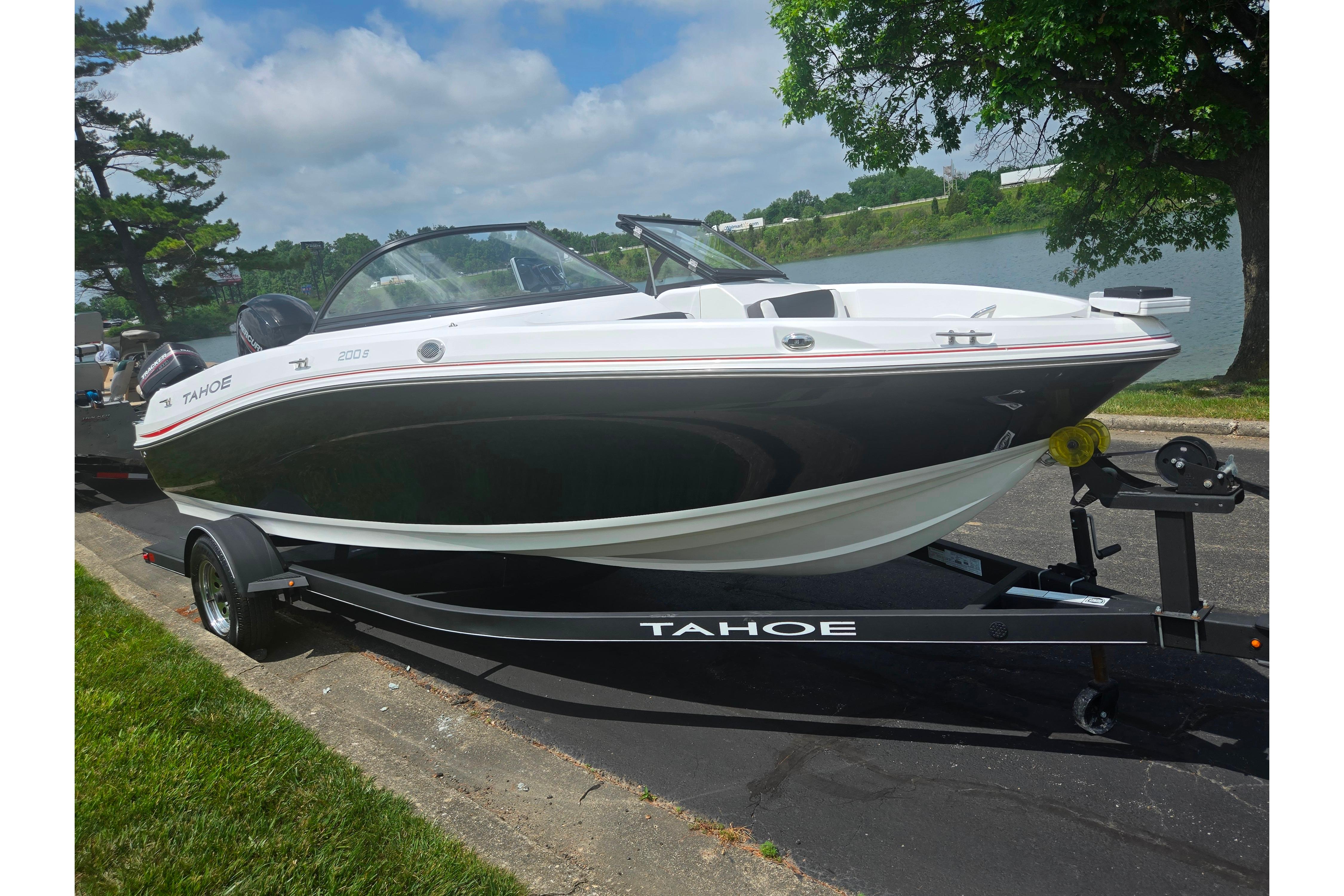 2023 Tahoe 200 S boat on trailer by a lakeside, under a clear sky.