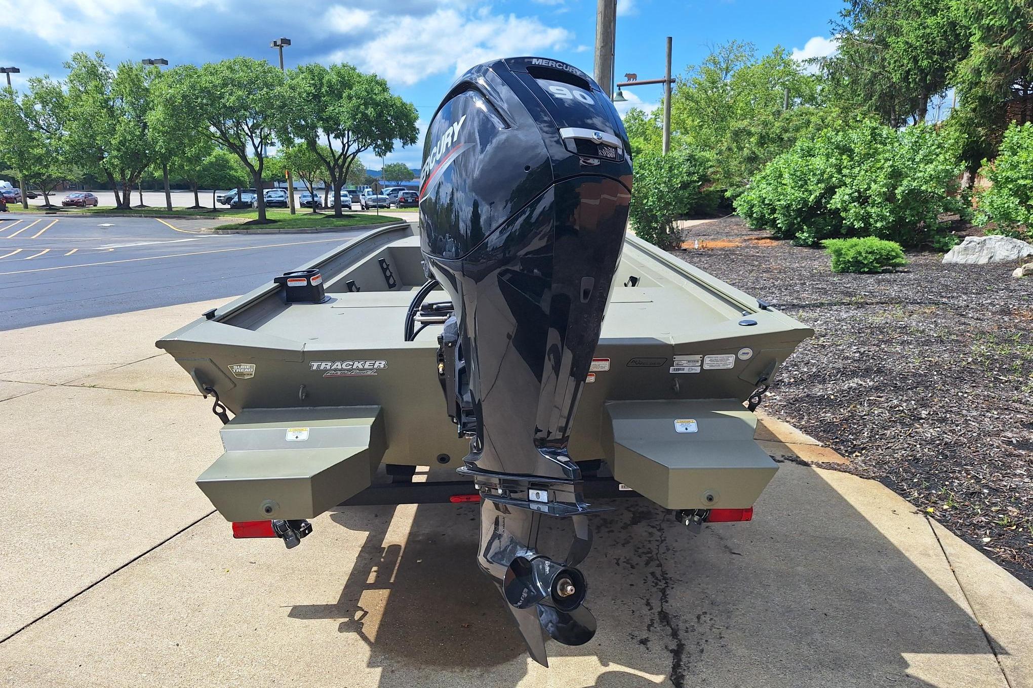 2026 Tracker Grizzly 1860 CC boat with Mercury outboard motor, parked outdoors.