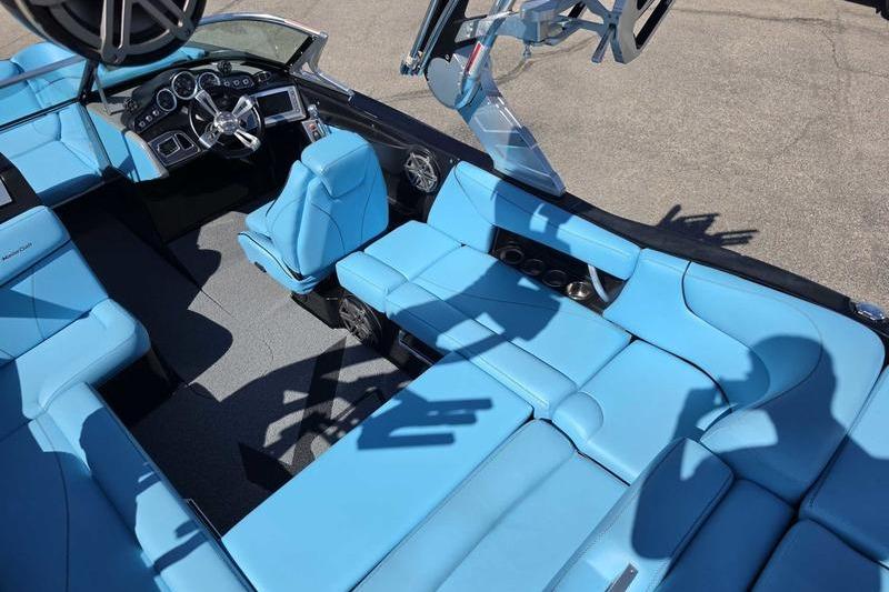 2017 MasterCraft X23 boat interior with blue seating and modern dashboard.