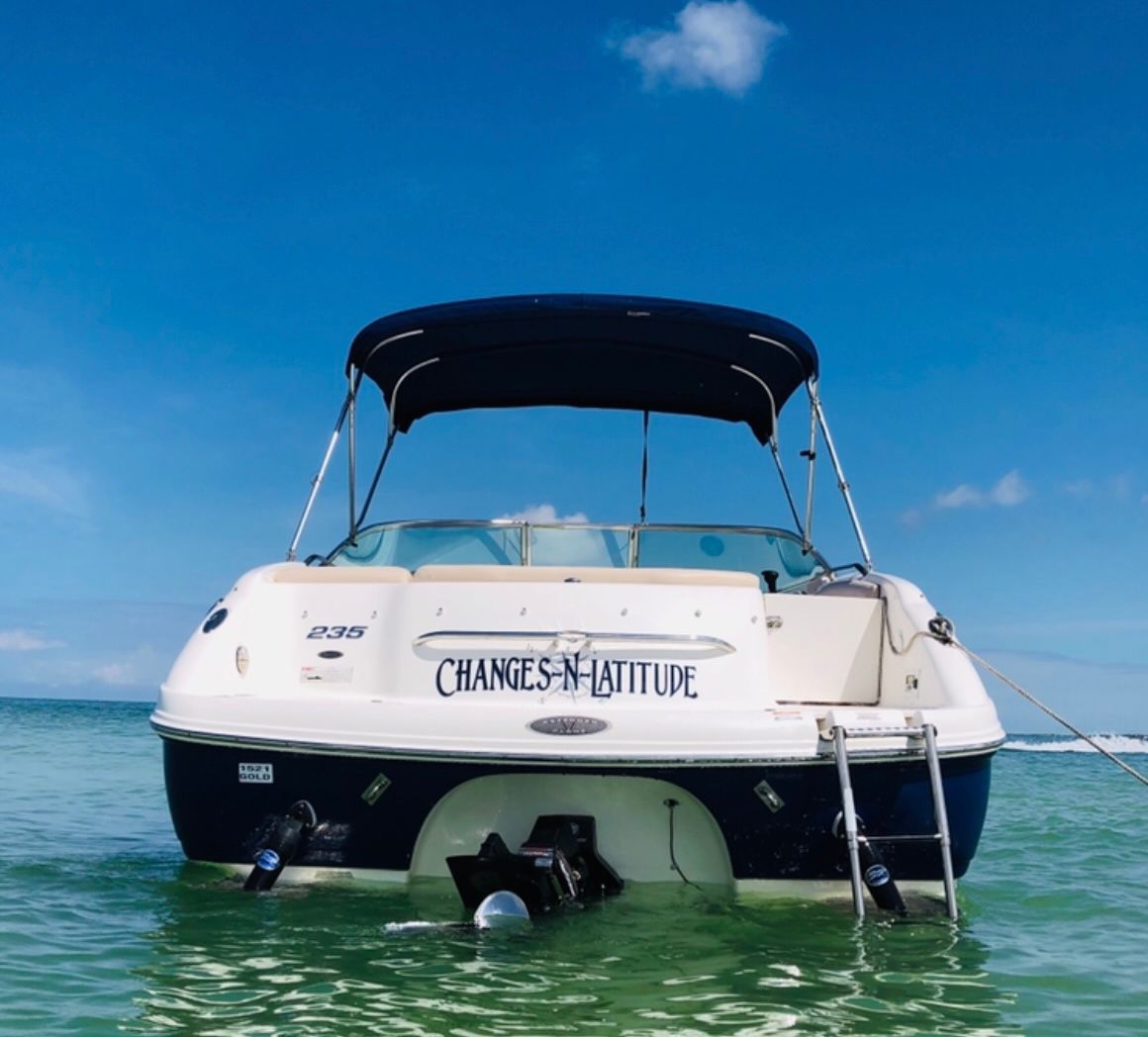 A 2007 Chaparral 235 SSi boat floats on clear water under a blue sky.