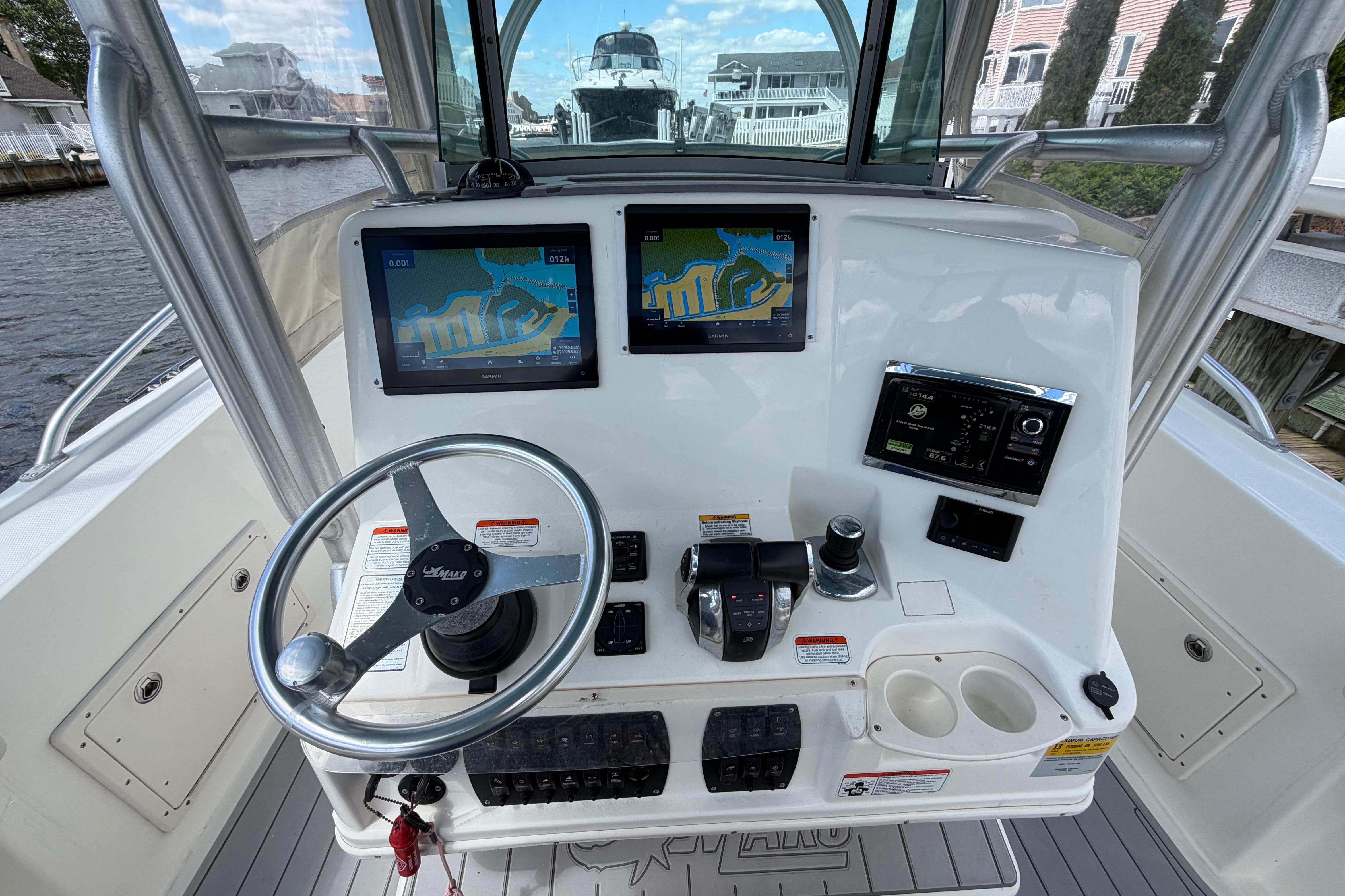 Center console of a 2017 Mako 284 boat with navigation screens and steering wheel.