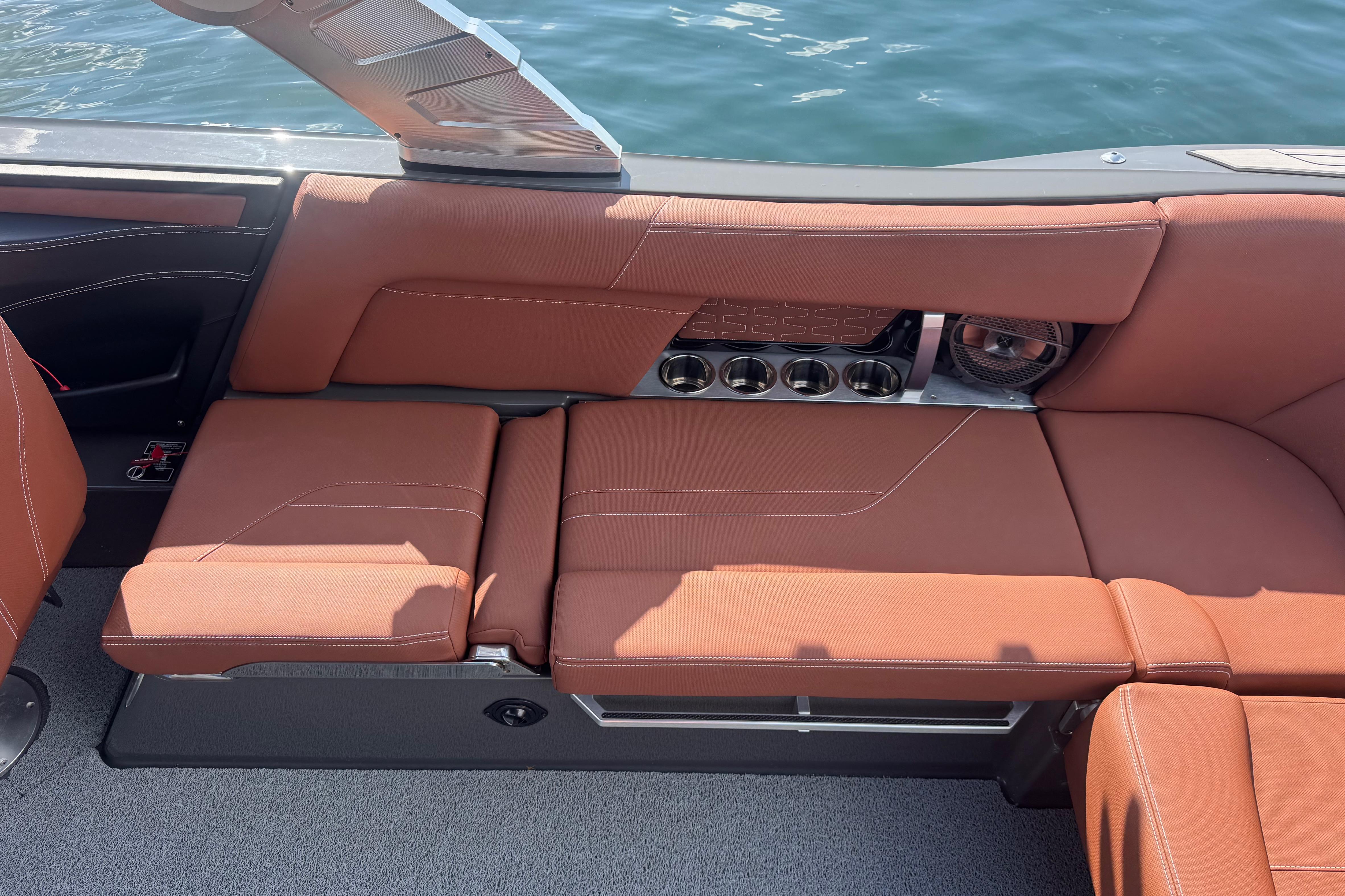 2021 MasterCraft X24 boat interior with brown leather seating and cup holders.