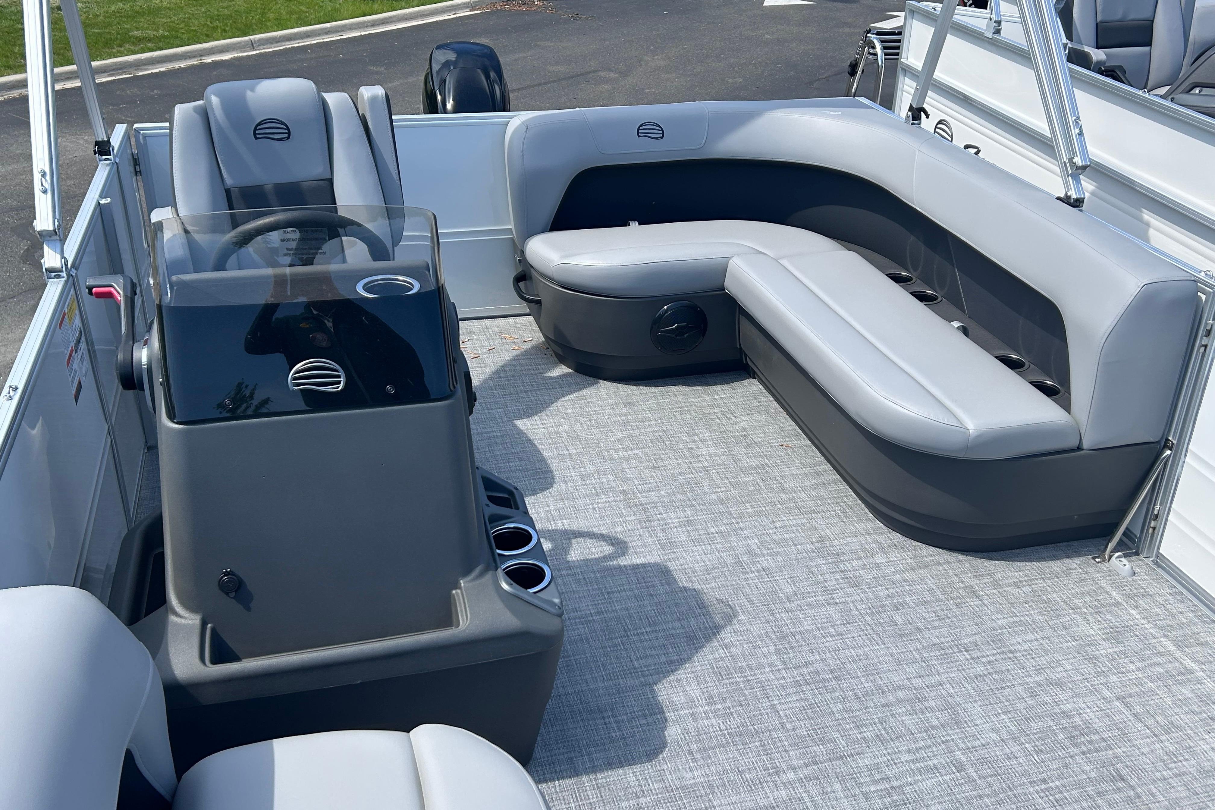 2026 Sun Tracker Party Barge 16 DLX interior with gray seating and steering console.