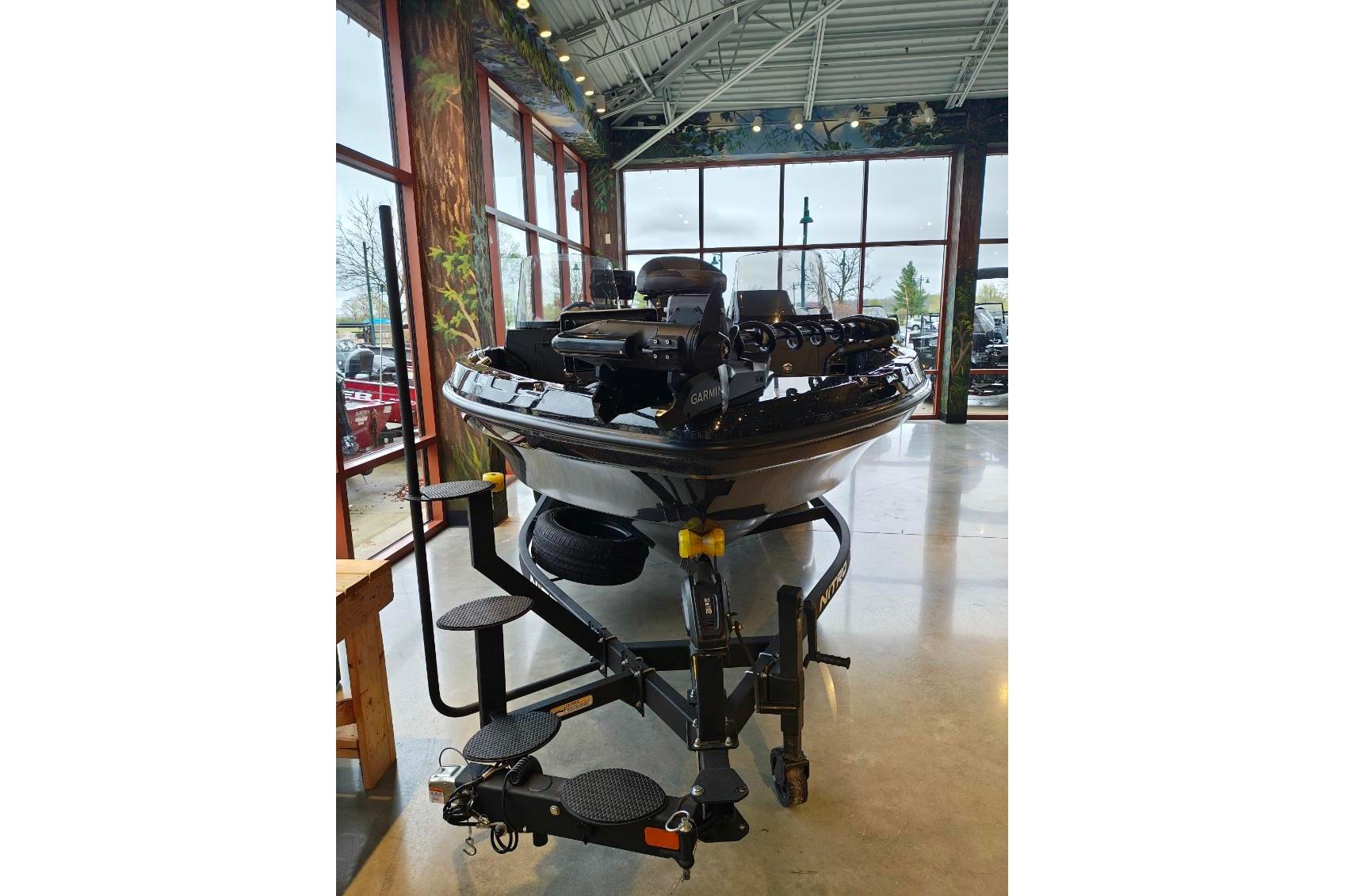 2026 Nitro ZV21 boat displayed indoors with trailer, surrounded by large windows.