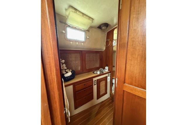 1982 Lancer 45 Motorsailer interior with wooden cabinetry and compact sink area.