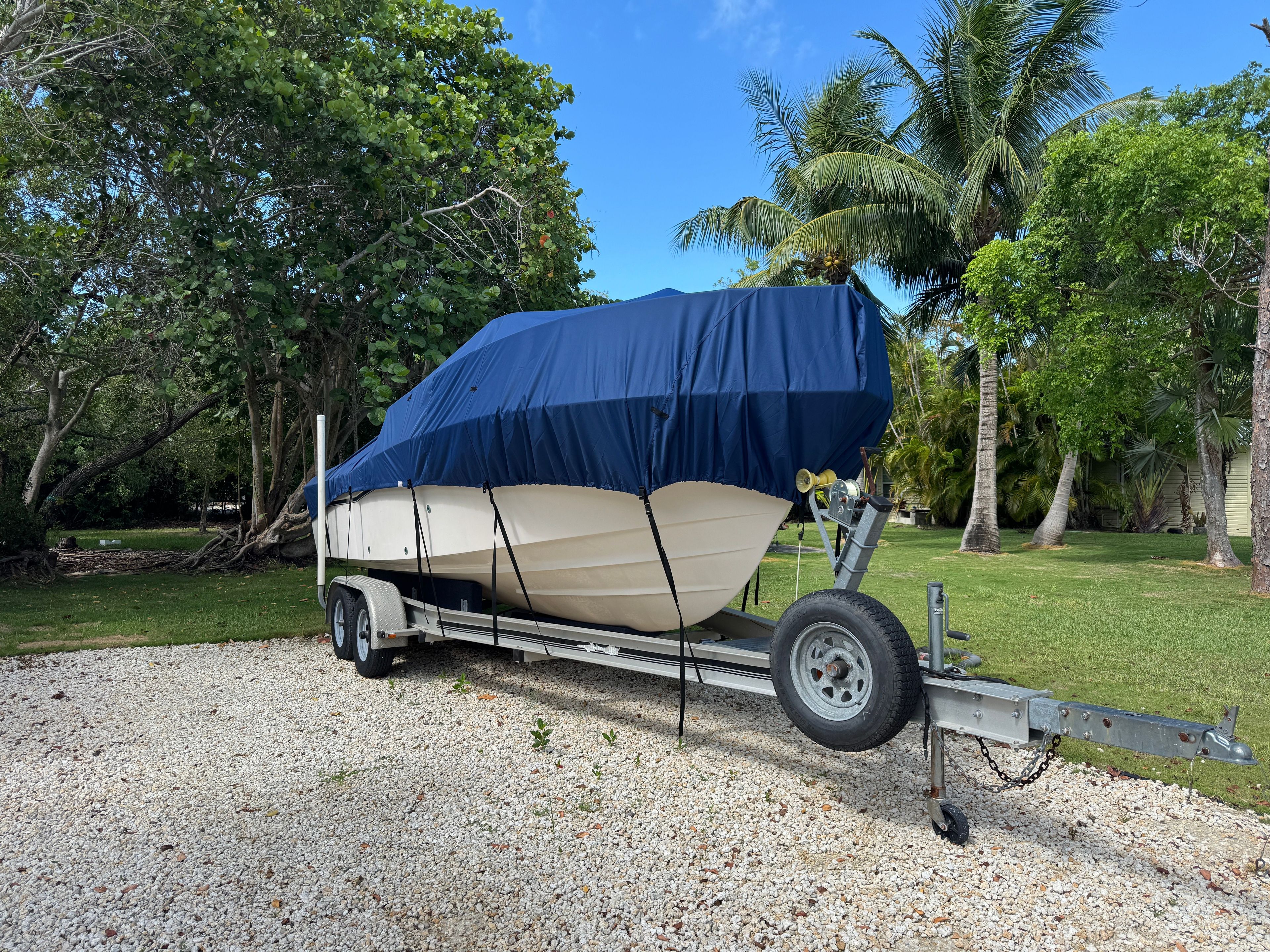 A 2005 Grady-White Seafarer 226 on a trailer, covered with a blue tarp.