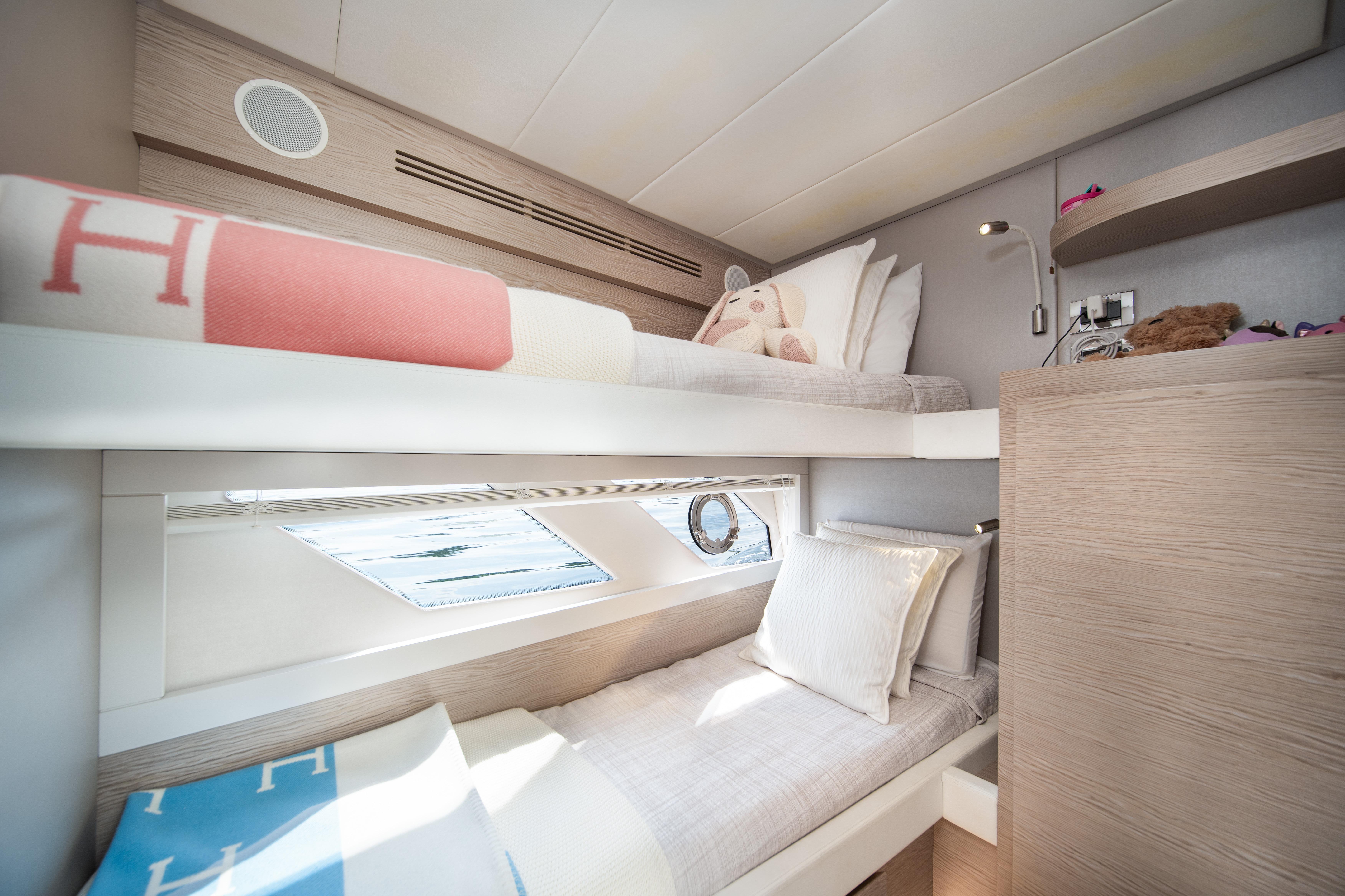 Luxurious 2019 Filippetti S55 yacht cabin with cozy bunk beds and modern decor.