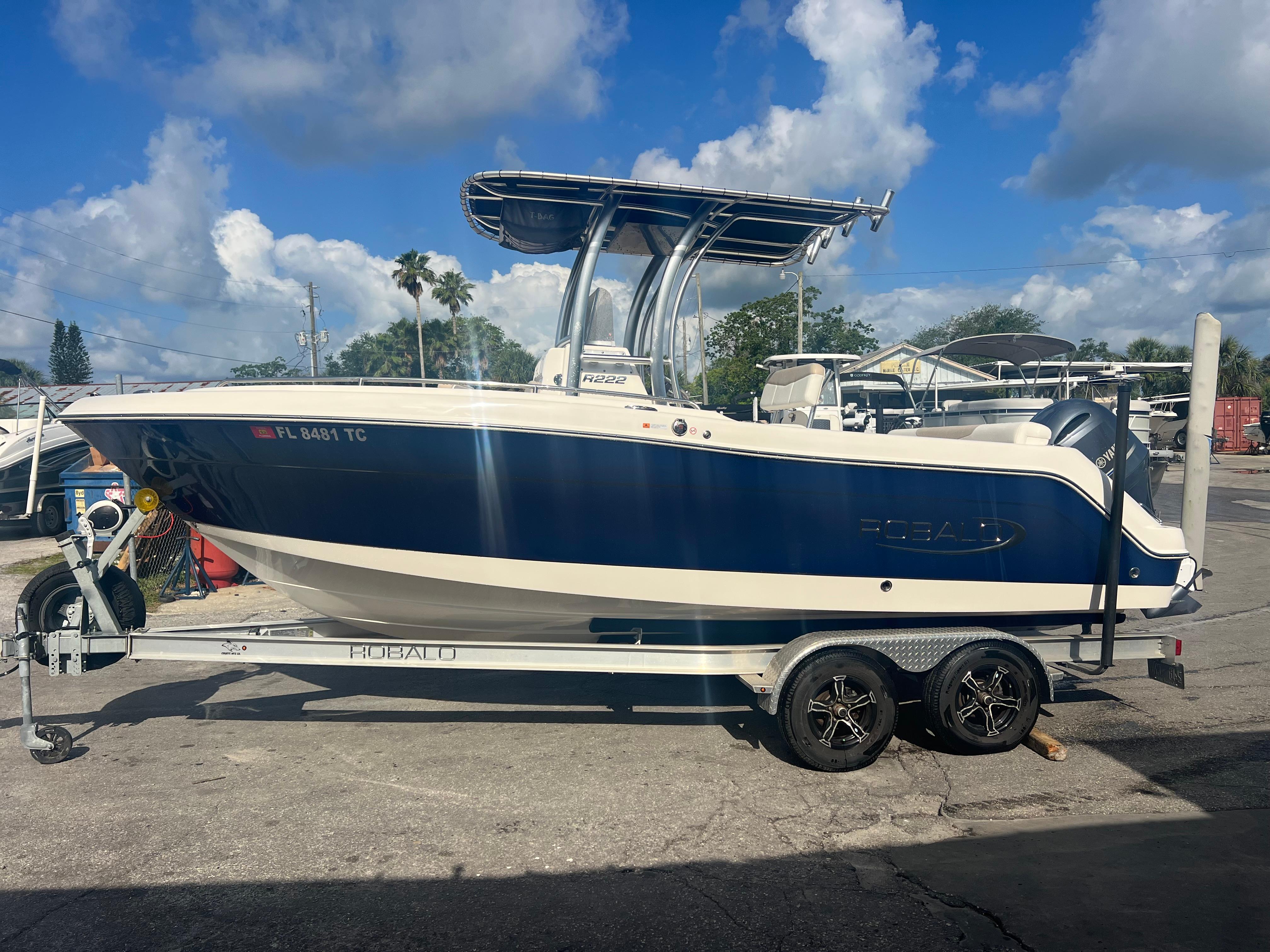2022 Robalo R222 Center Console boat on trailer under blue sky.