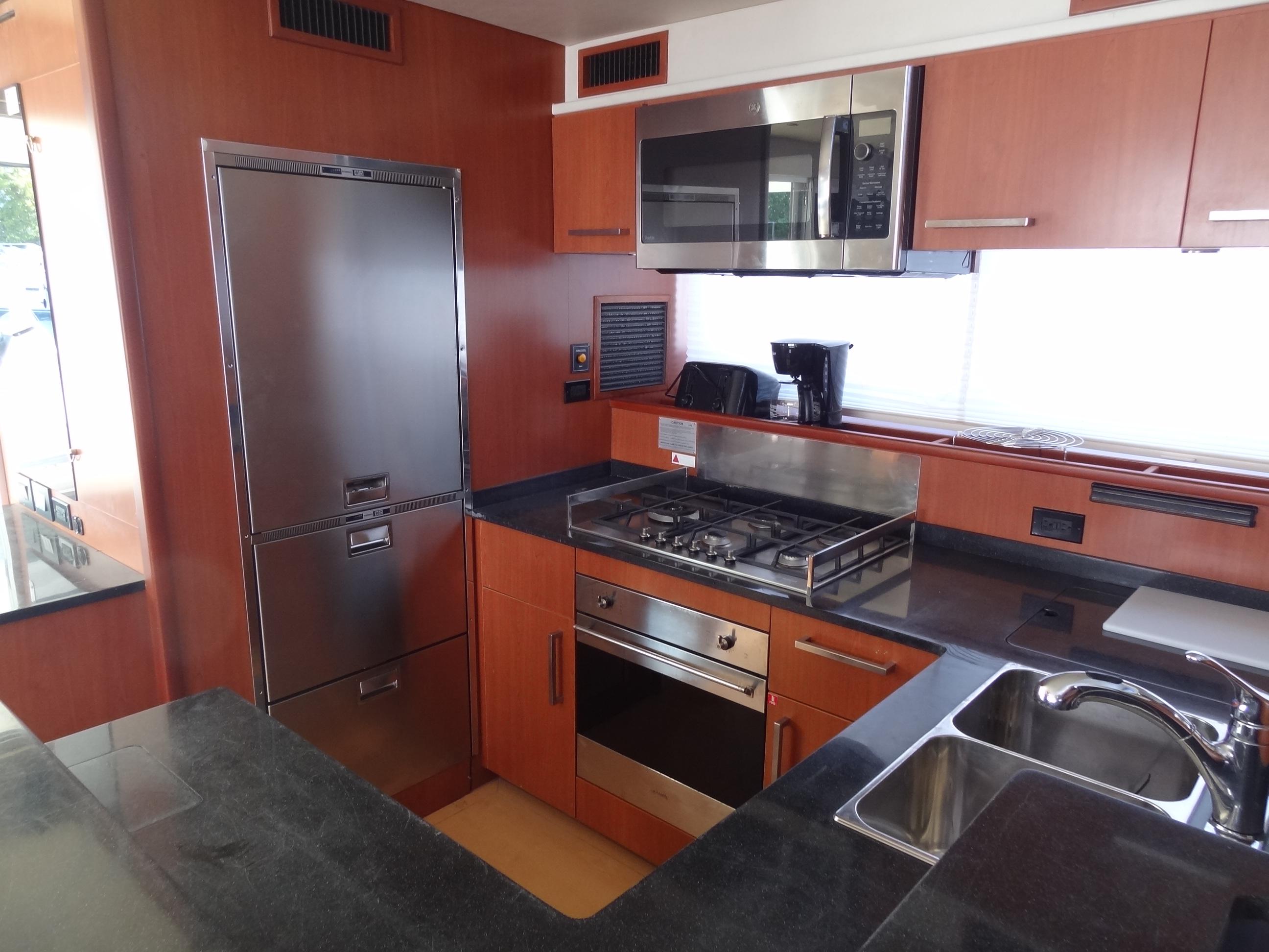 Modern kitchen in a 2014 Leopard 58 yacht with stainless steel appliances.