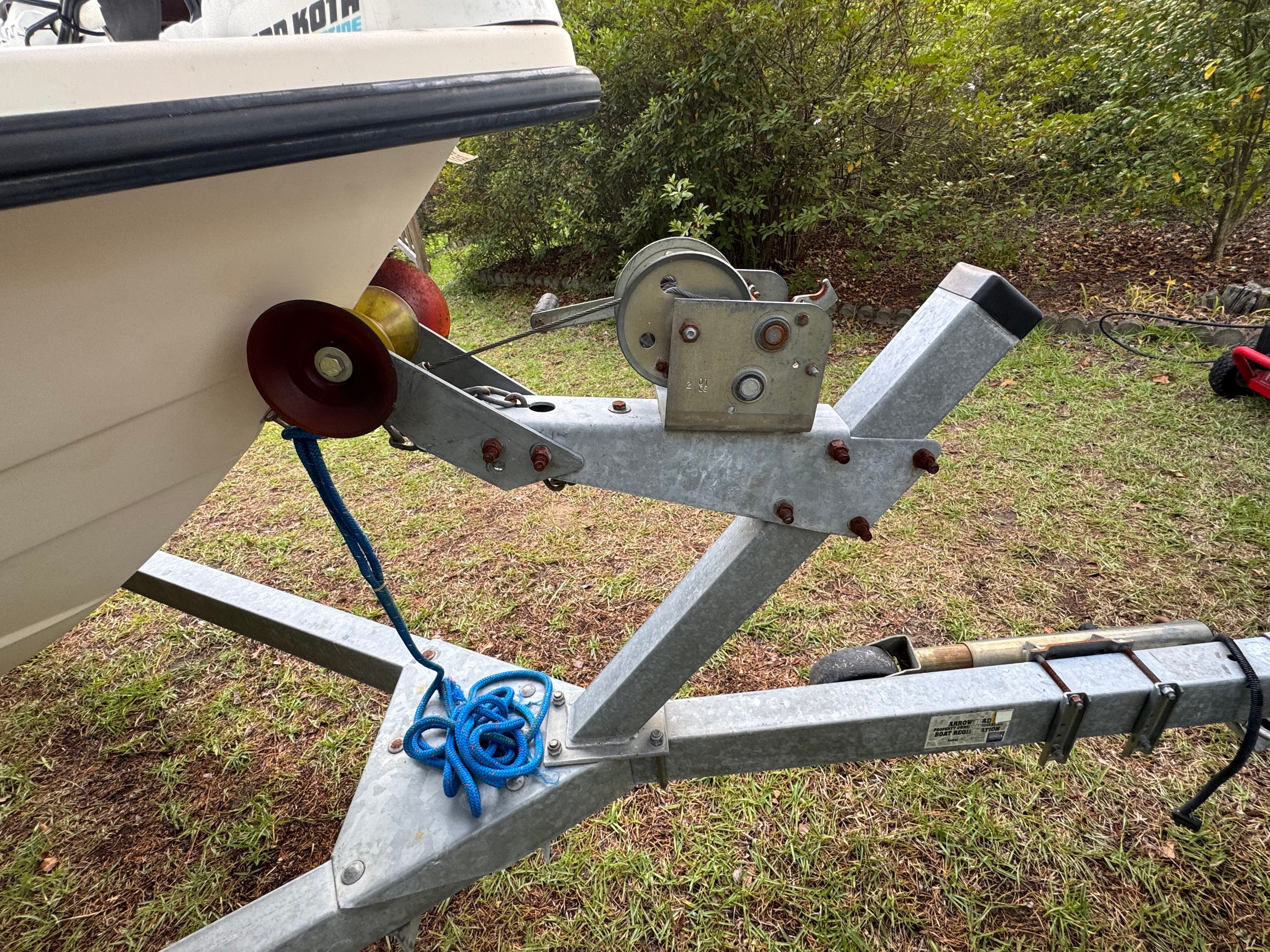 Close-up of a boat trailer with a winch and blue rope.