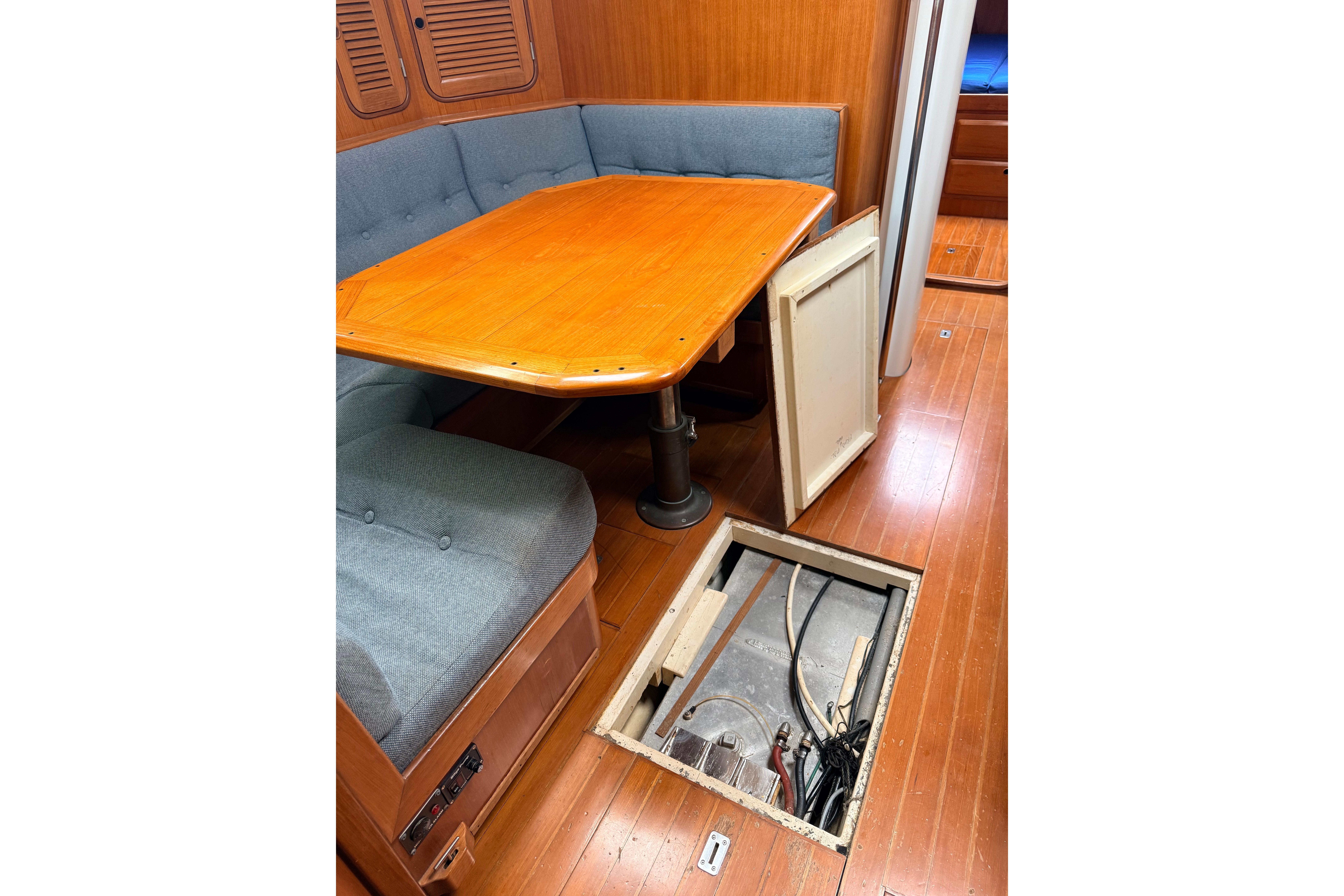 Interior of 1987 Norseman 400 sailboat with open floor hatch and wooden table.
