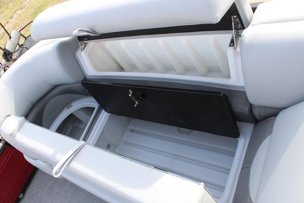 2025 Regency 230 DL3 boat storage compartment with open lid, showcasing spacious interior.