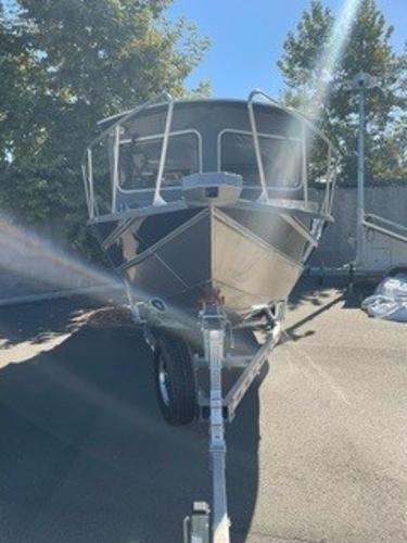 2025 Spartan 2600 Olympia boat on trailer, parked outdoors under clear sky.