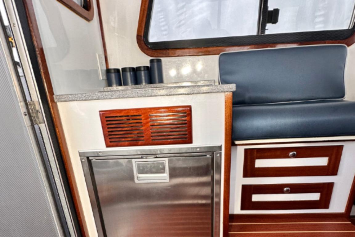 Interior of a 2009 Hunt 35 boat with seating, drawers, and a compact kitchenette.