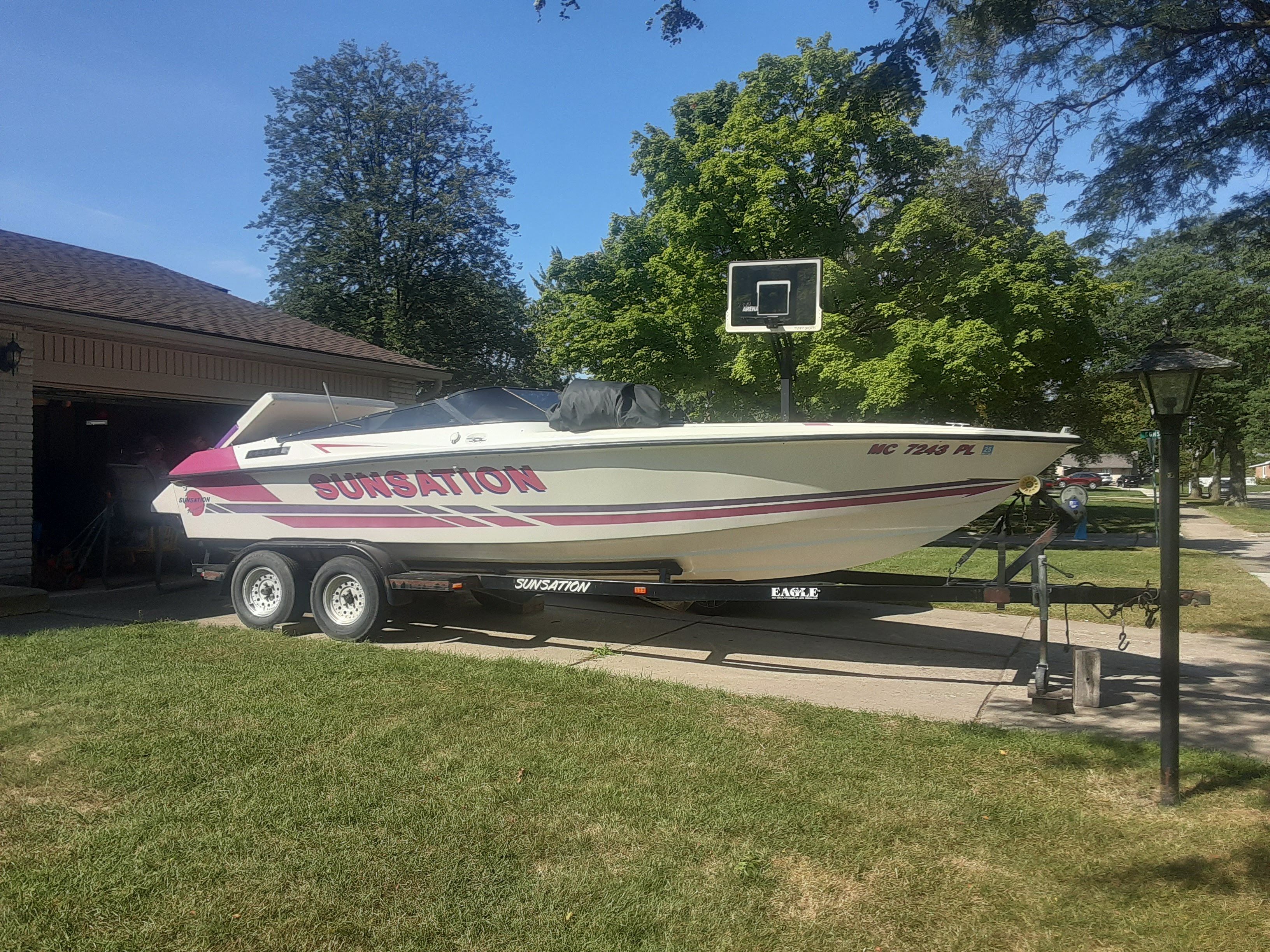 1993 Sunsation Aggressor boat parked on trailer outdoors.