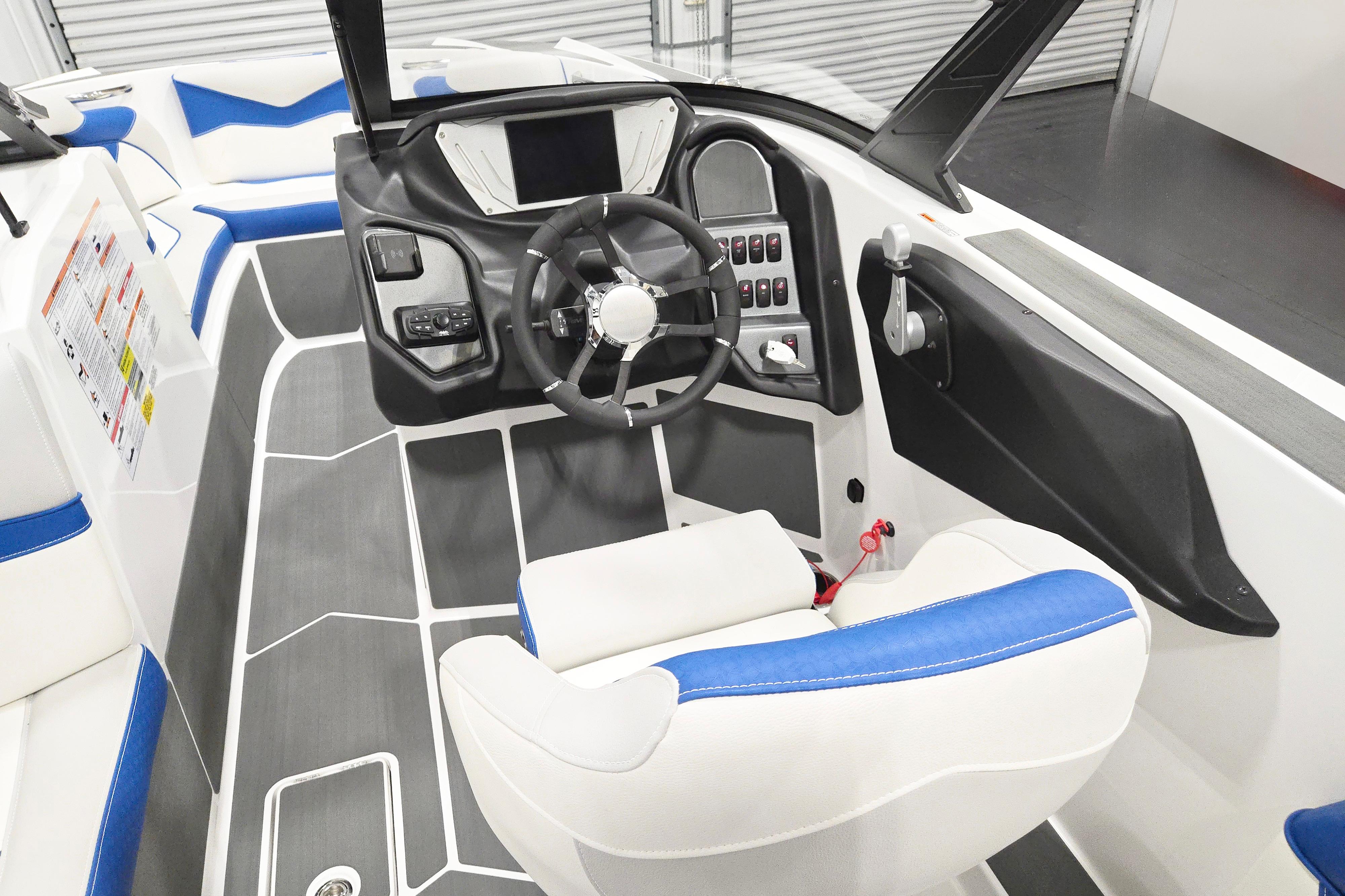 2026 Supreme S220 boat interior with modern dashboard, steering wheel, and blue-accented seating.