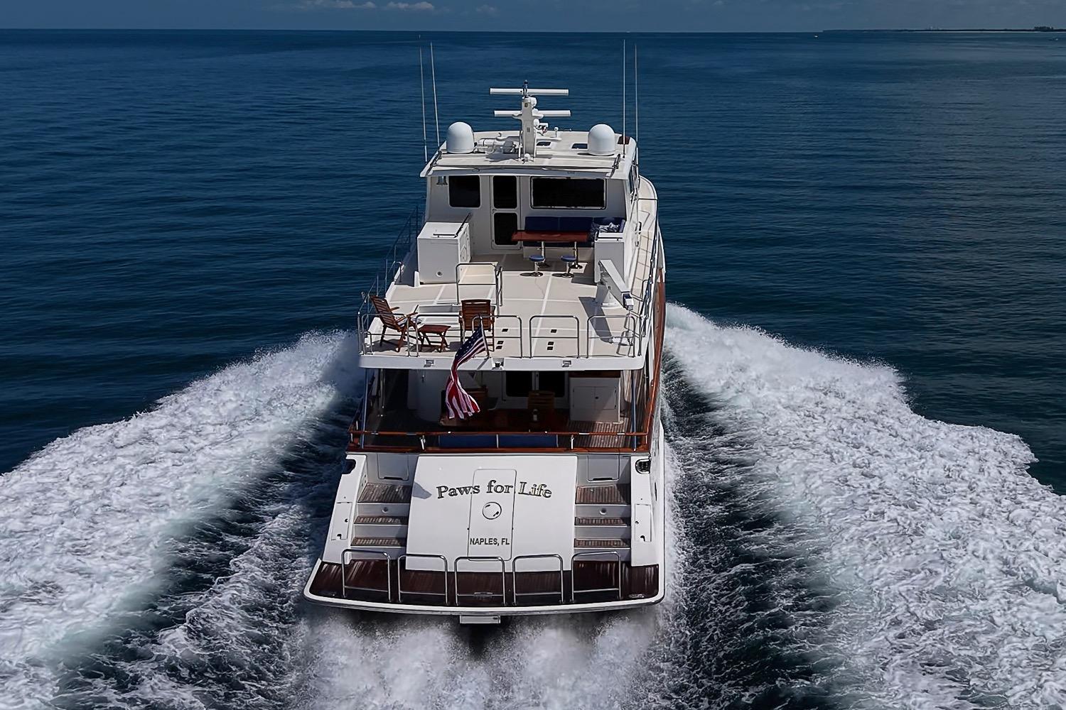 2014 Marlow 80 Explorer yacht cruising on open water, rear view.