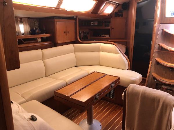 Luxurious interior of 2001 Jeanneau 45.2 yacht with cream leather seating and wooden accents.