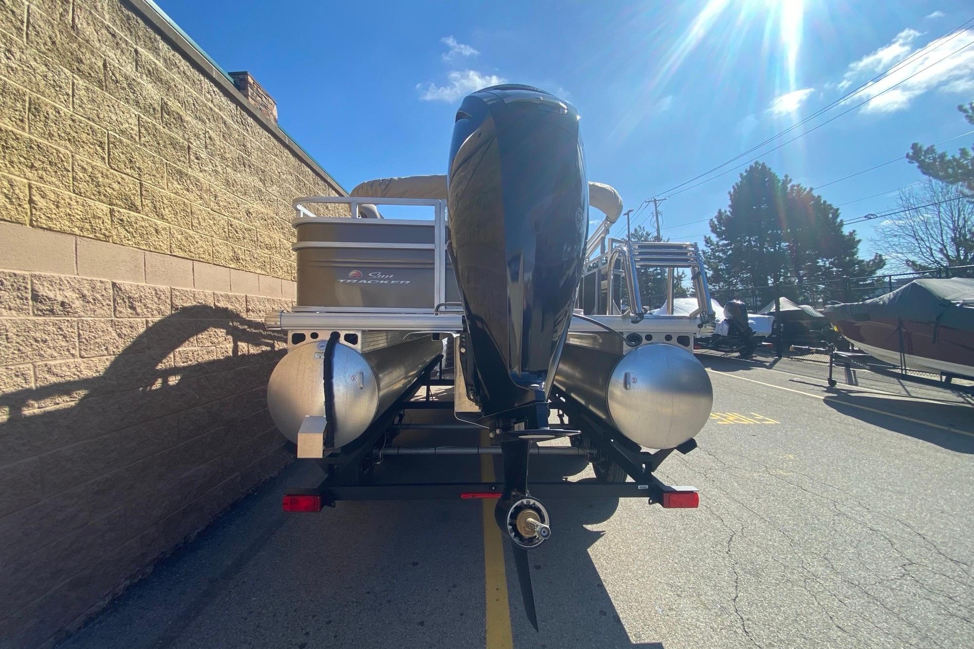 2025 Sun Tracker SportFish 20 DLX pontoon boat, rear view, parked outdoors.