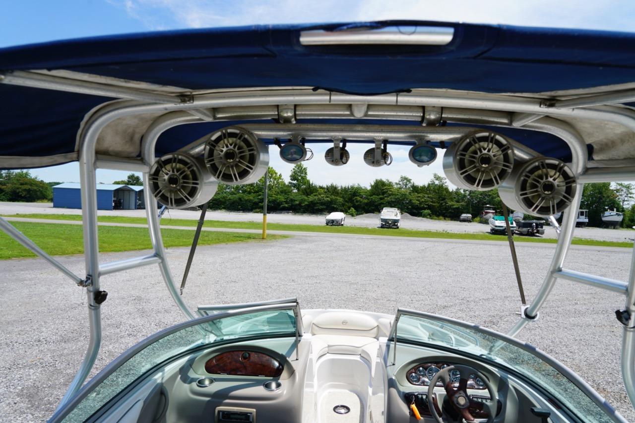 2004 Crownline 216 LS boat interior with speakers and canopy, parked outdoors.