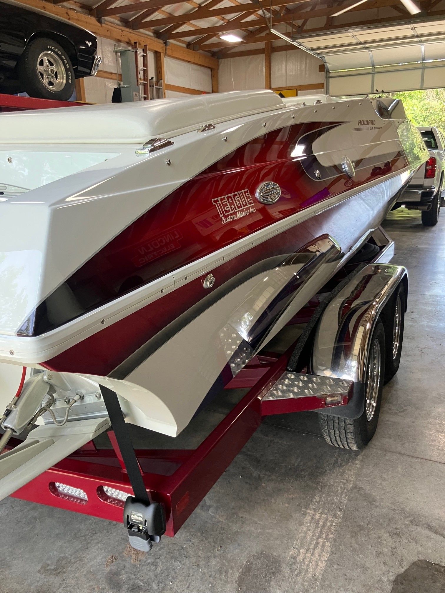 A 2003 Howard Bullet boat on a trailer in a garage.