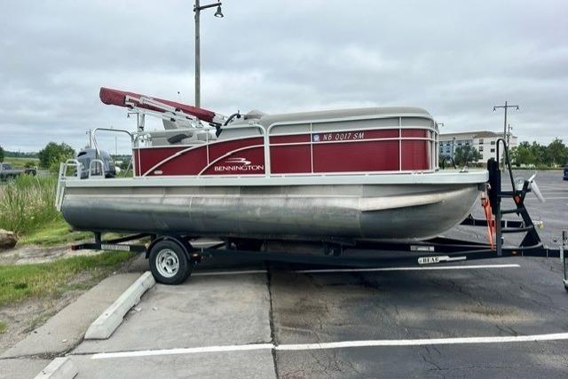 2021 Bennington 205SL pontoon boat on trailer in parking lot.