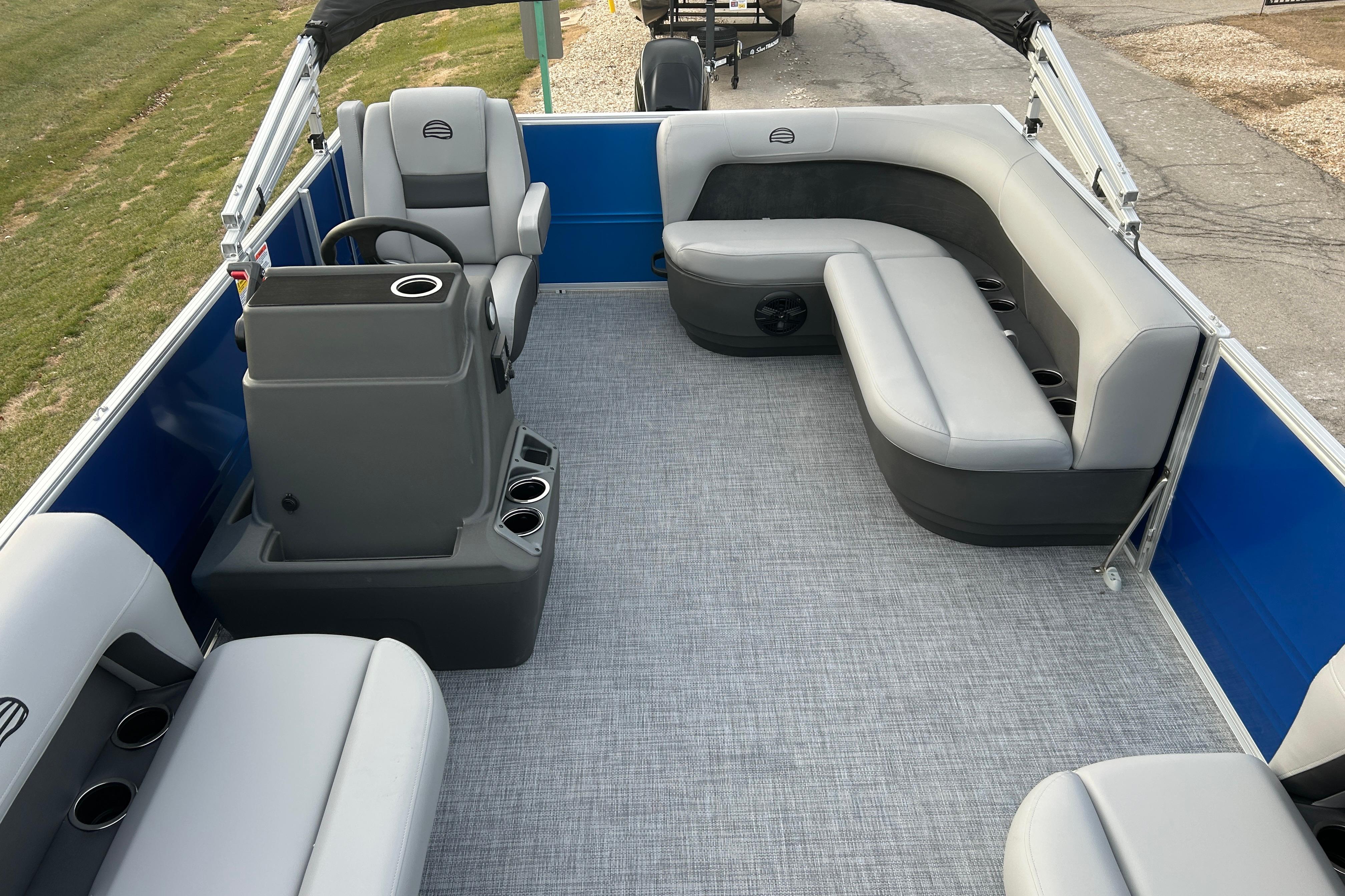 2026 Sun Tracker Party Barge 16 DLX interior with gray seating and steering console.