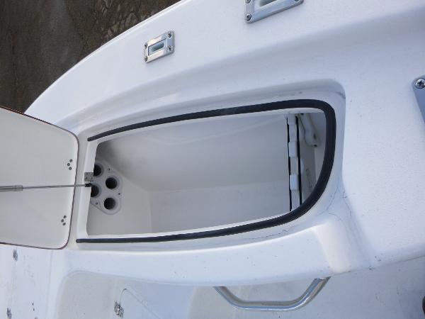 Open storage compartment on 2025 Sea Pro 230 Bay boat, showcasing interior design.