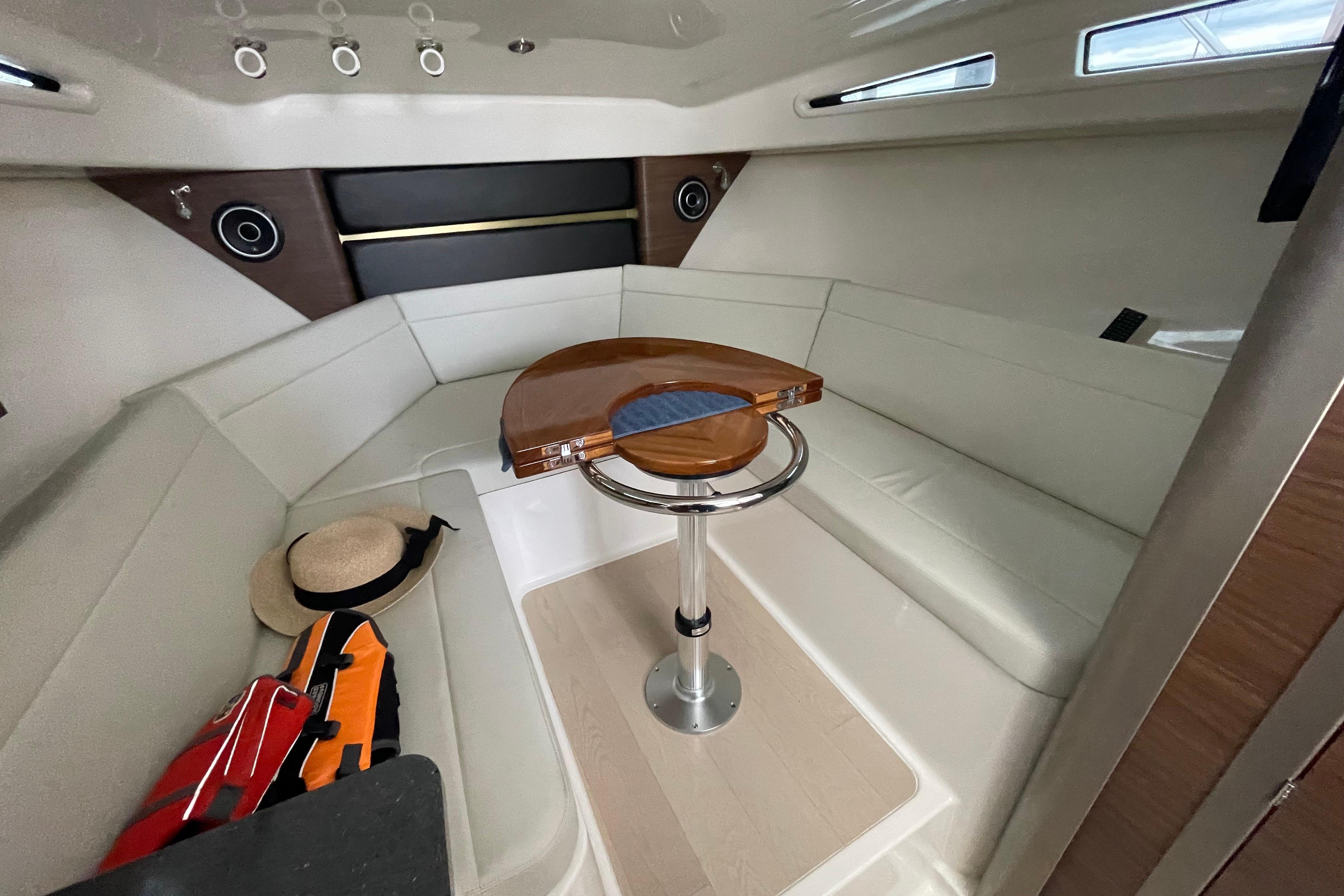 2023 Boston Whaler 325 Conquest cabin interior with seating, table, and accessories.