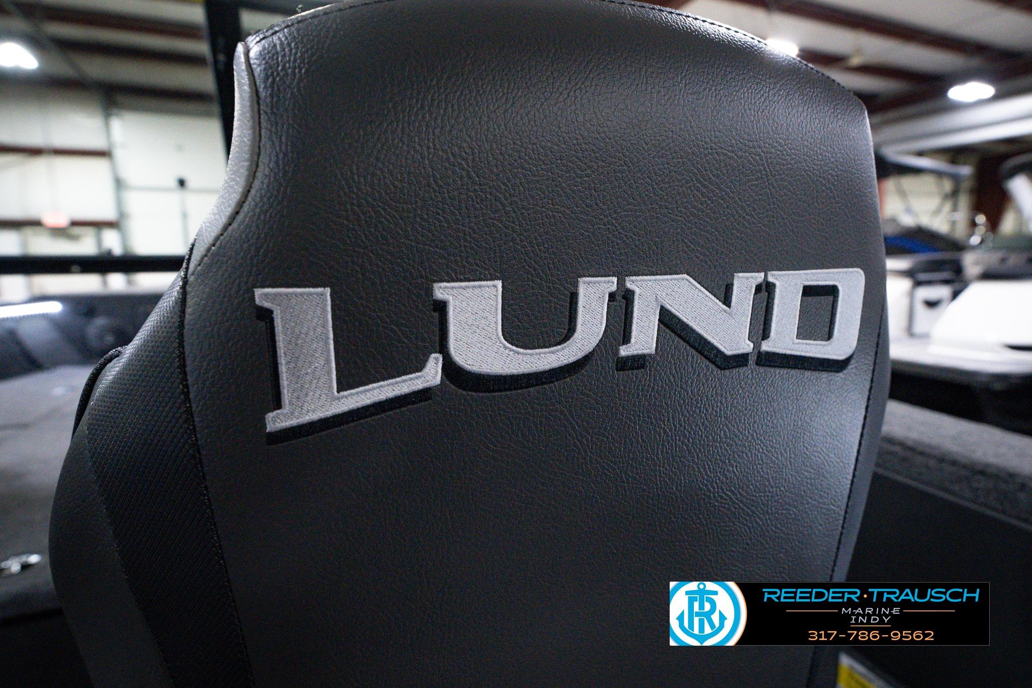 2026 Lund 1875 Impact XS SS boat seat with logo in showroom setting.