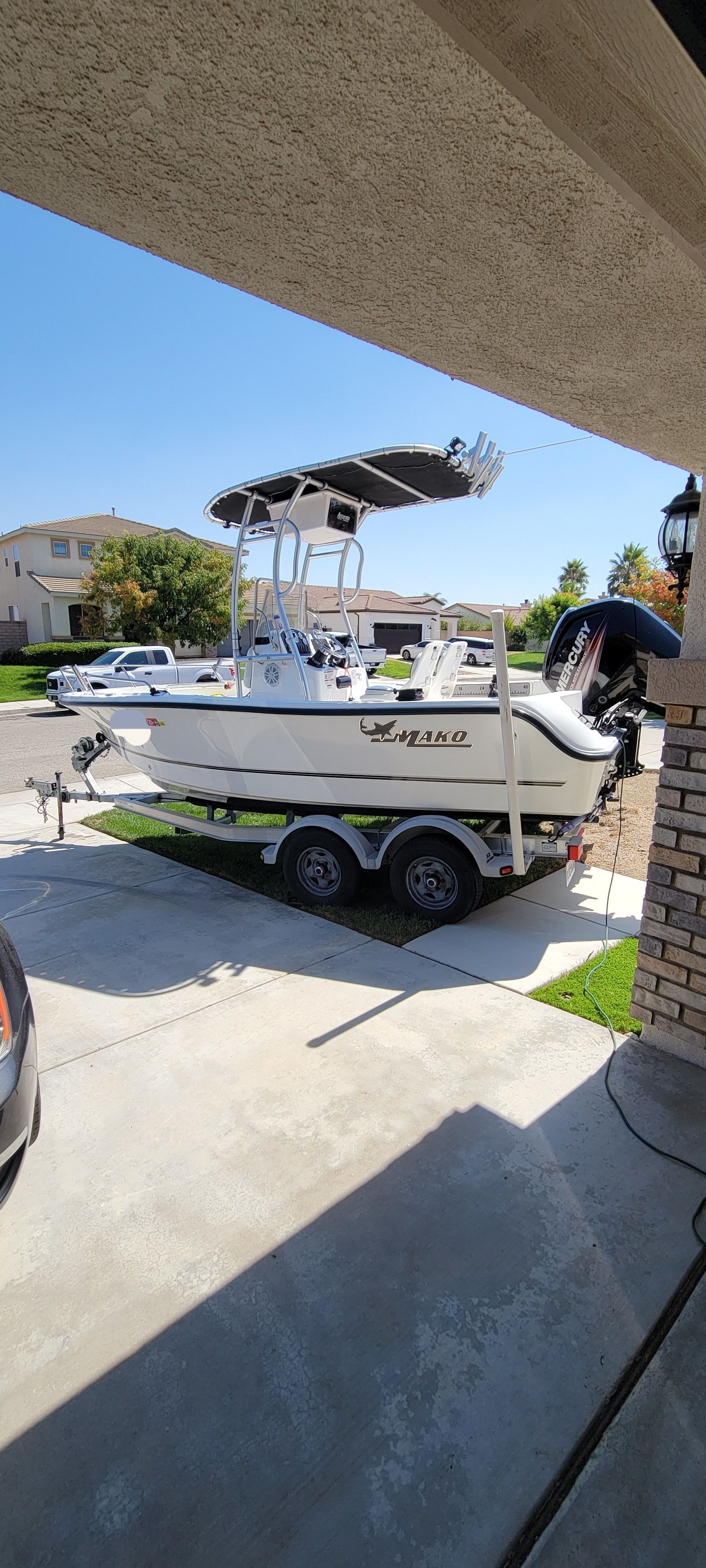 A 2017 Mako 184 Center Console boat on a trailer in a driveway.