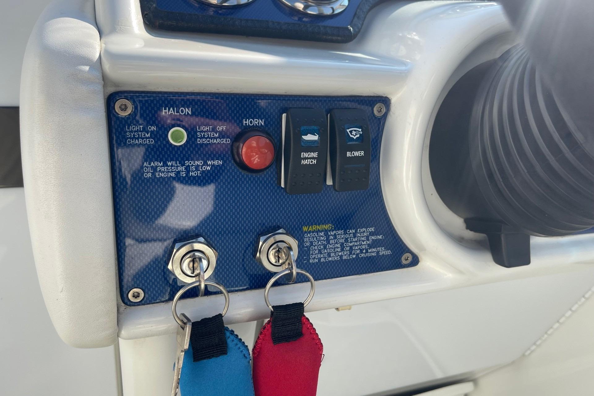 Control panel of a 2004 Formula 382 FASTech boat with switches and warning labels.