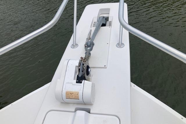 Bow of 2000 Mainship 430 Trawler with anchor and railing, on calm water.